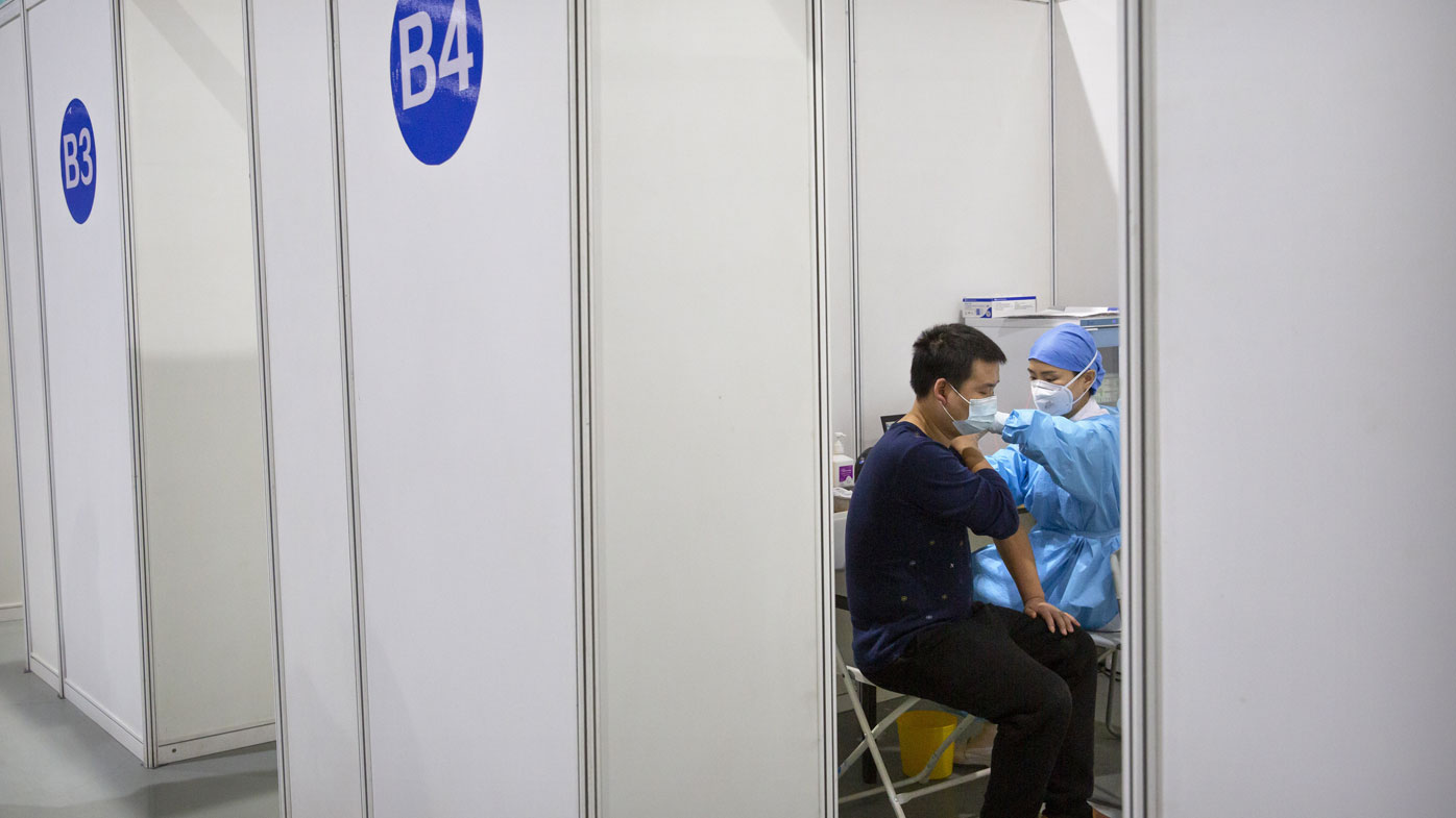 A medical worker gives a coronavirus vaccine shot to a patient at a vaccination facility in Beijing, Friday, Jan. 15, 2021