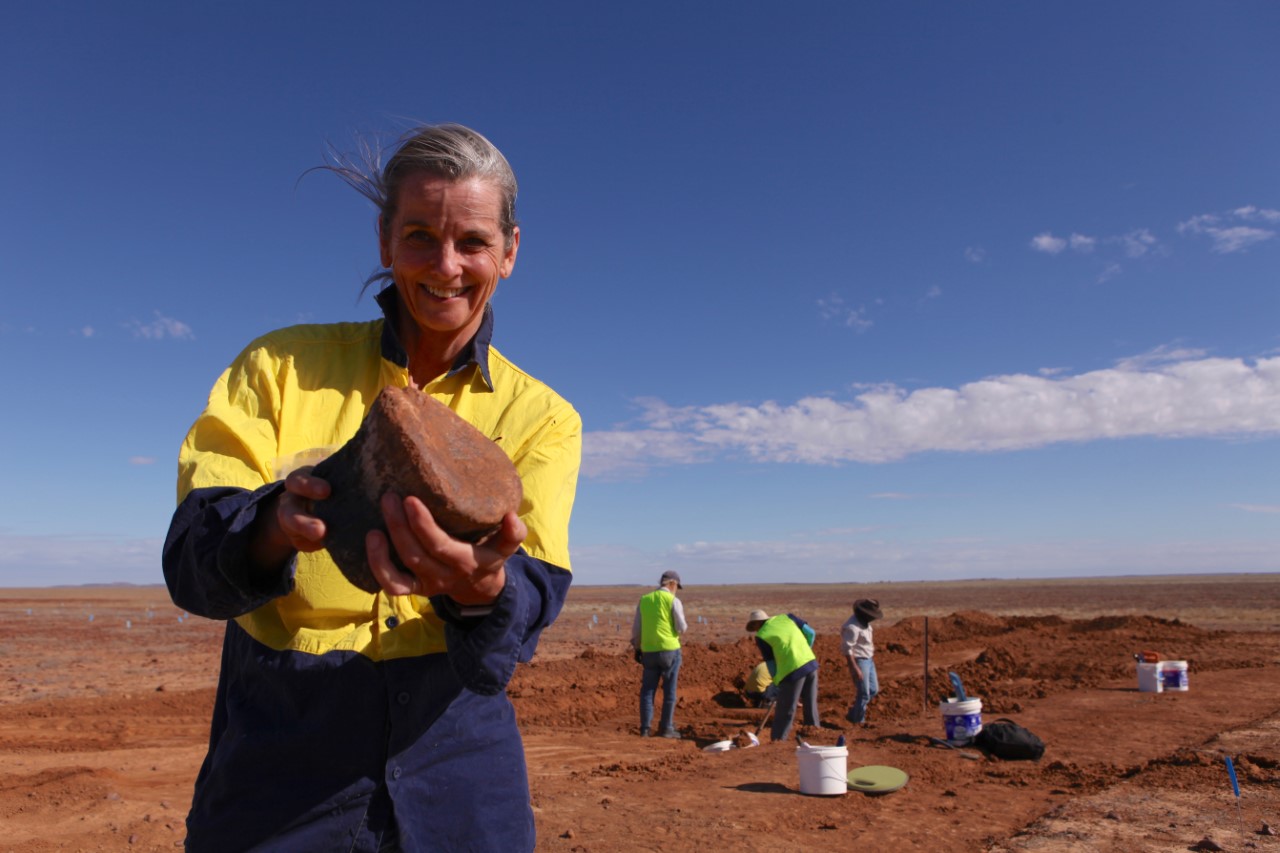 Robyn Mackenzie, Director and palaeontologist for the Eromanga Natural History Museum, holds up a dinosaur bone.