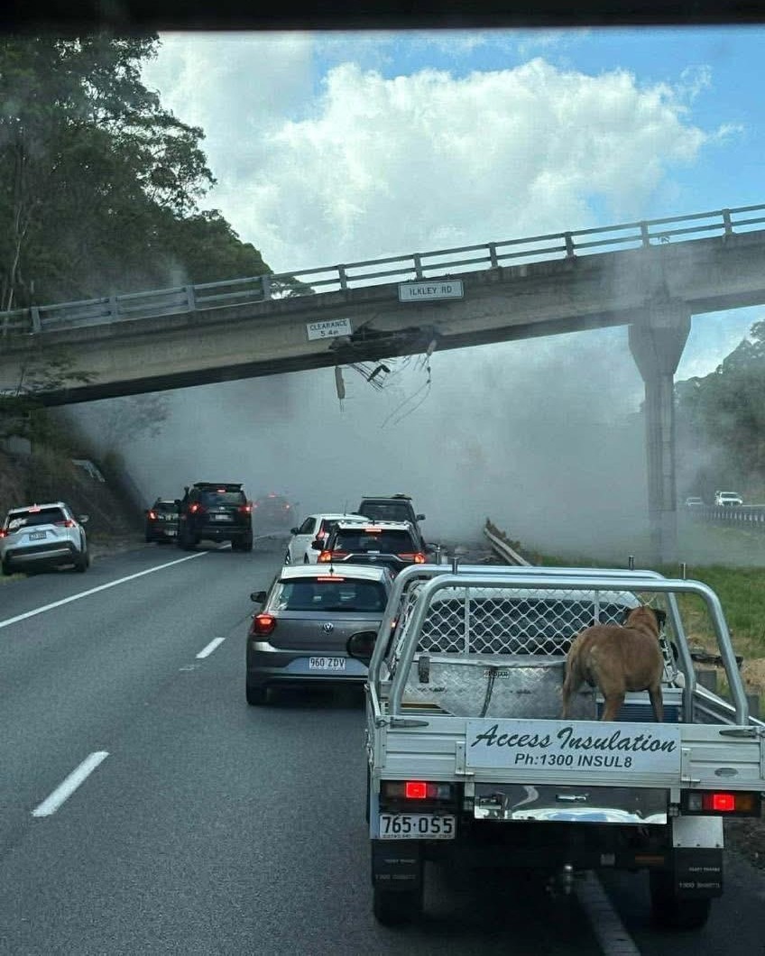 Major highway closed after truck carrying excavator hits overhead bridge