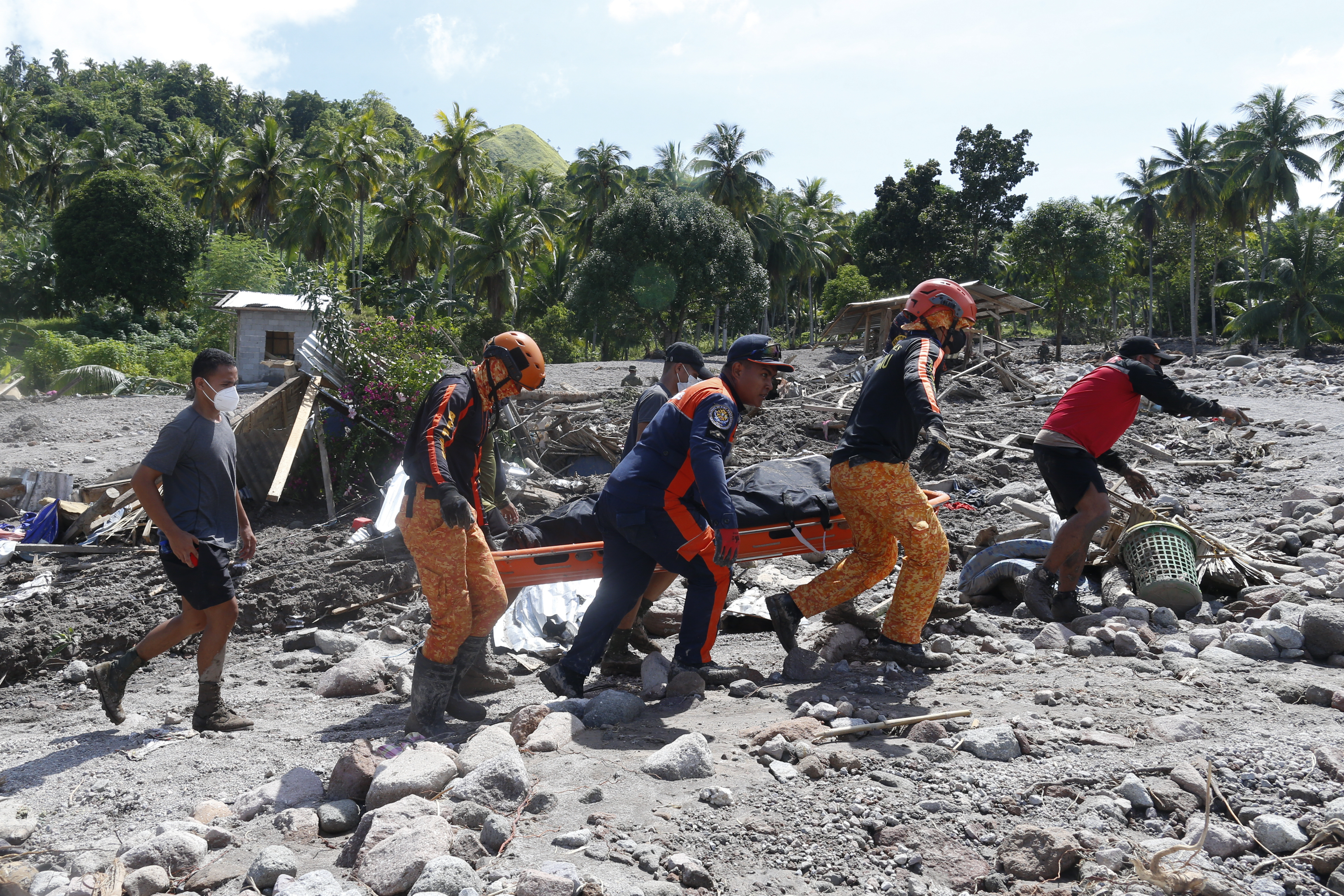 Rescuers carry a body at Maguindanao's Datu Odin Sinsuat town, southern Philippines on Sunday Oct. 30, 2022. 