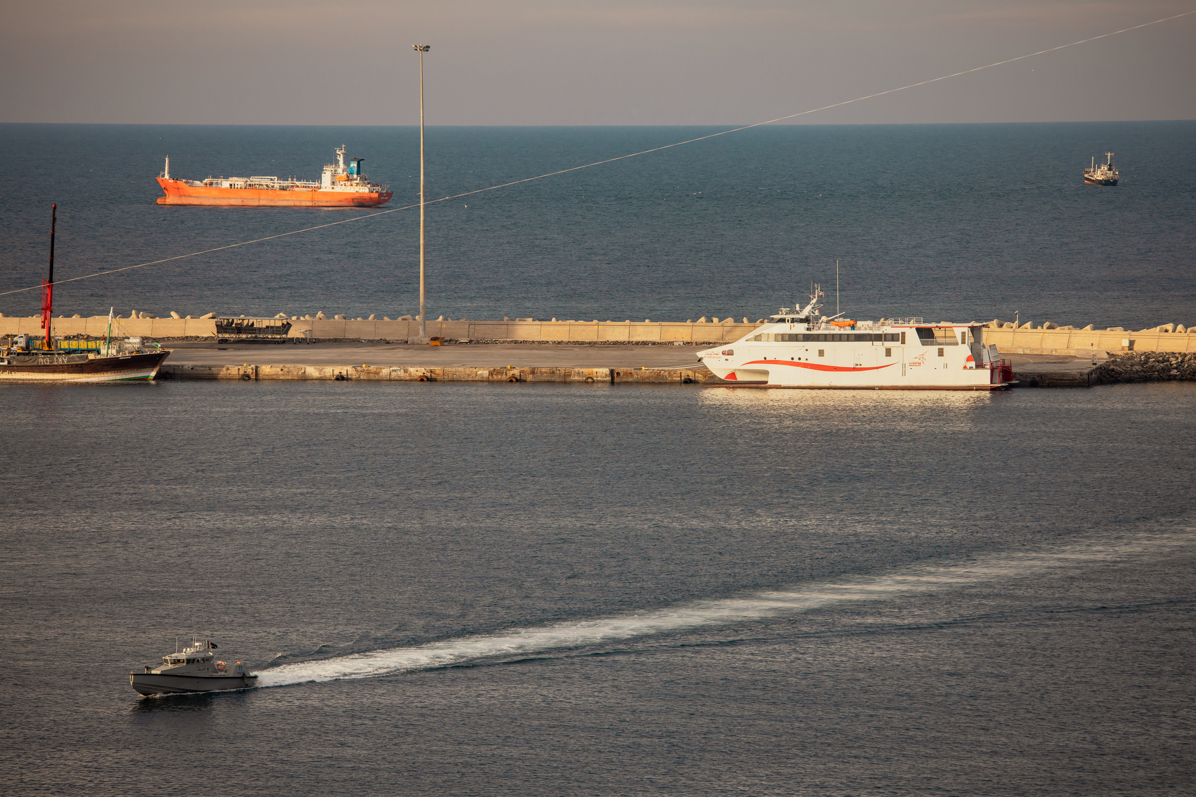 MUSCAT, OMAN - MARCH 30: A police speed boat patrols the port as oil tankers and high speed crafts sit anchored at Muscat Anchorage near the Strait of Hormuz on March 30, 2026 in Muscat, Oman. Several Chinese-owned vessels were reportedly able to transit the Strait of Hormuz today, the day after U.S. President Donald Trump said Iran would allow 20 ships to cross through the vital waterway. Maritime traffic through the Strait of Hormuz, which conveys about a fifth of the world's oil and gas, has 