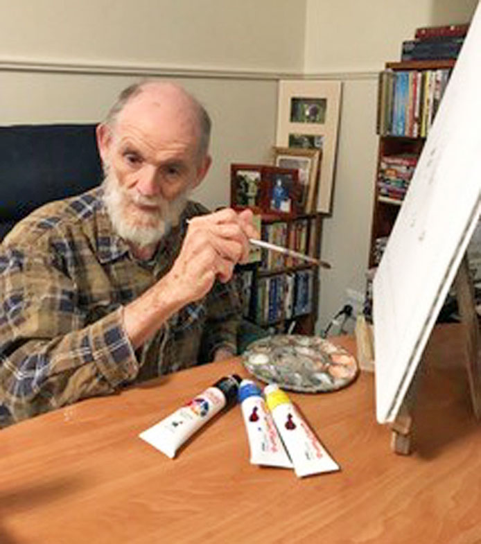 Malcolm works on his Archibald Prize entry while isolating in his room at Estia House.