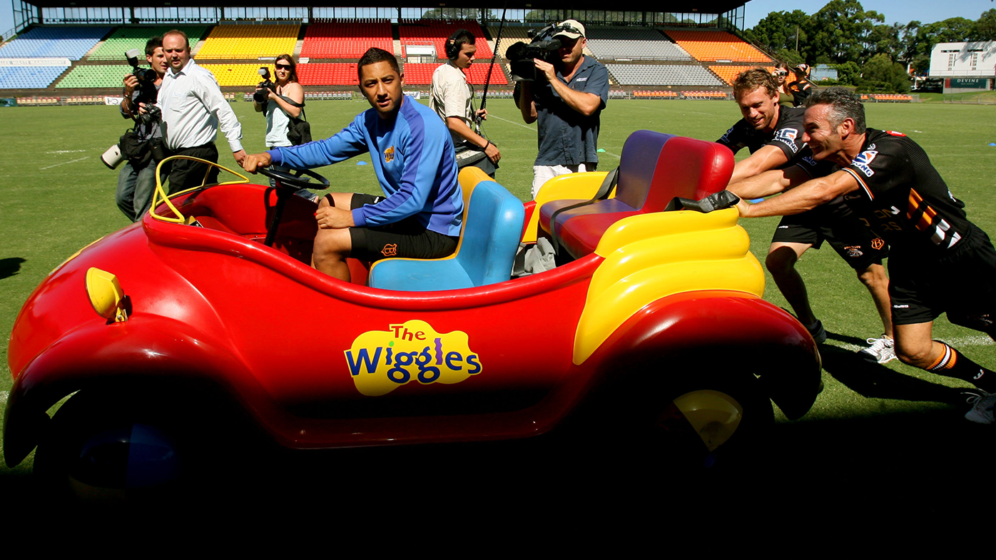Benji Marshall sitting in the Wiggles Big Red Car while Blue Wiggle Anthony Field and Brett Hodgson give the car a push.