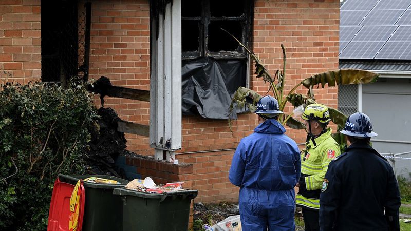 Police and fire crews outside of the Lalor Park home in Sydney's west where three children died in a fire in July.