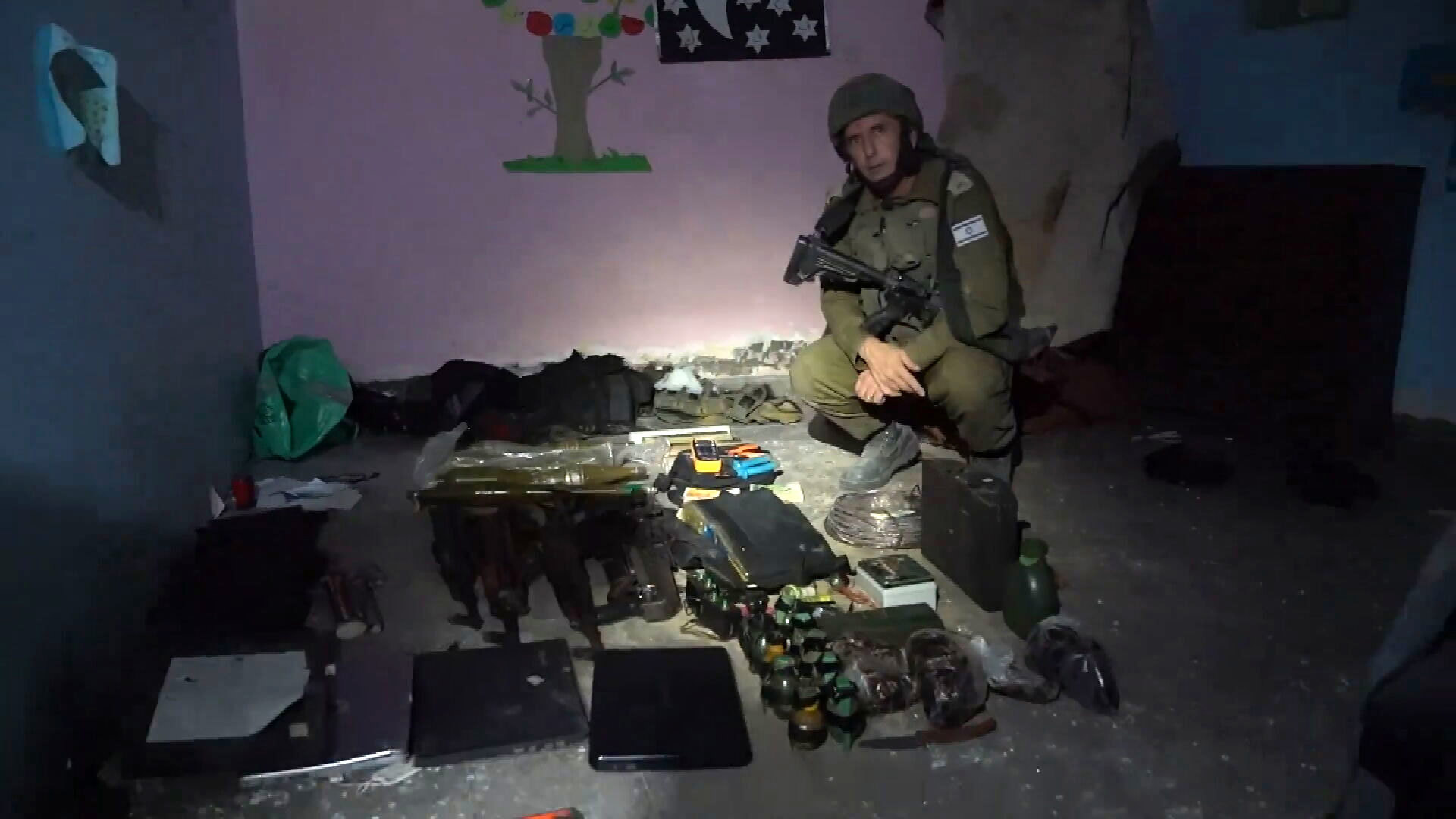 An IDF soldier crouches in a hospital.