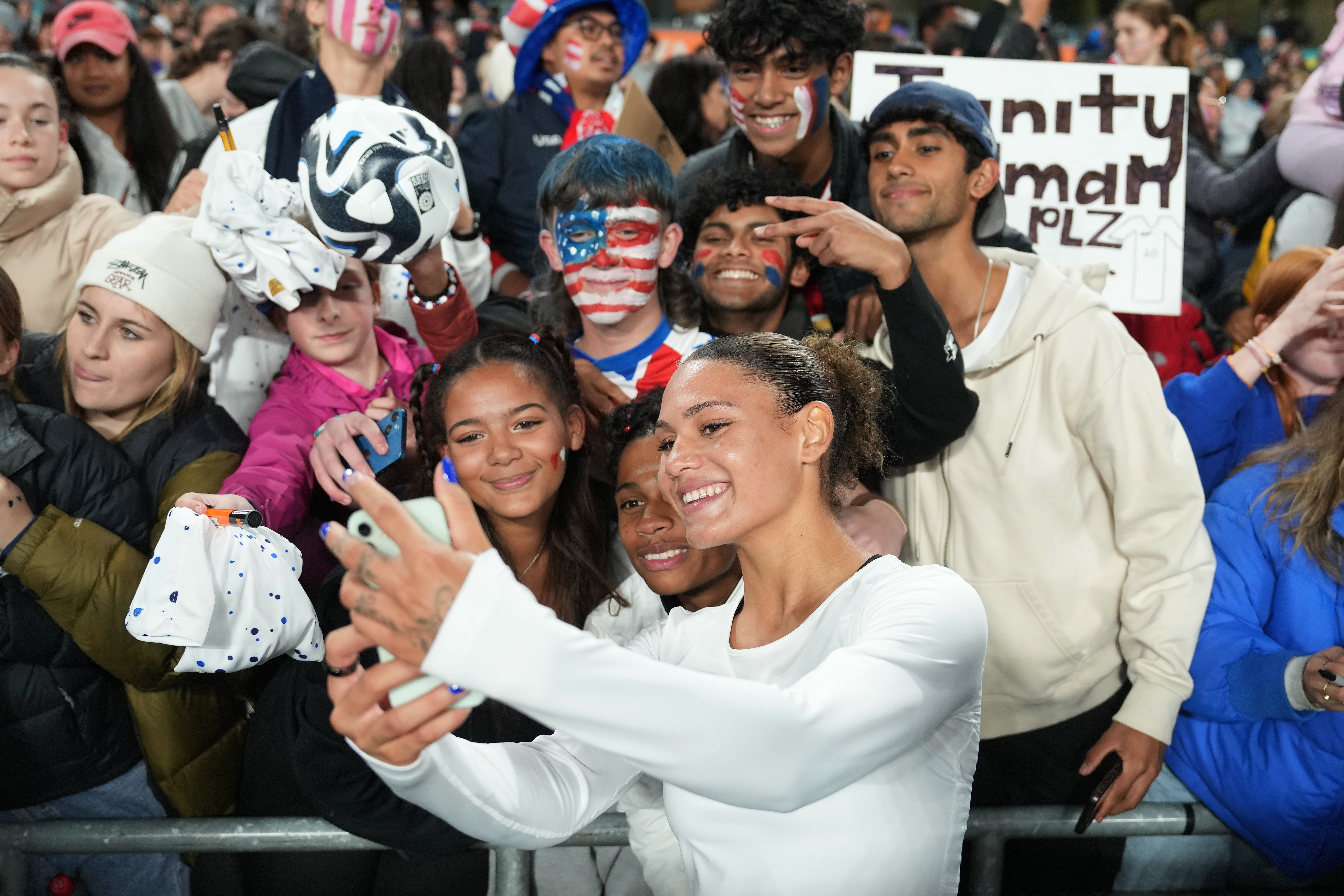 Trinity Rodman of the United States takes selfies with fans after losing to Portugal.