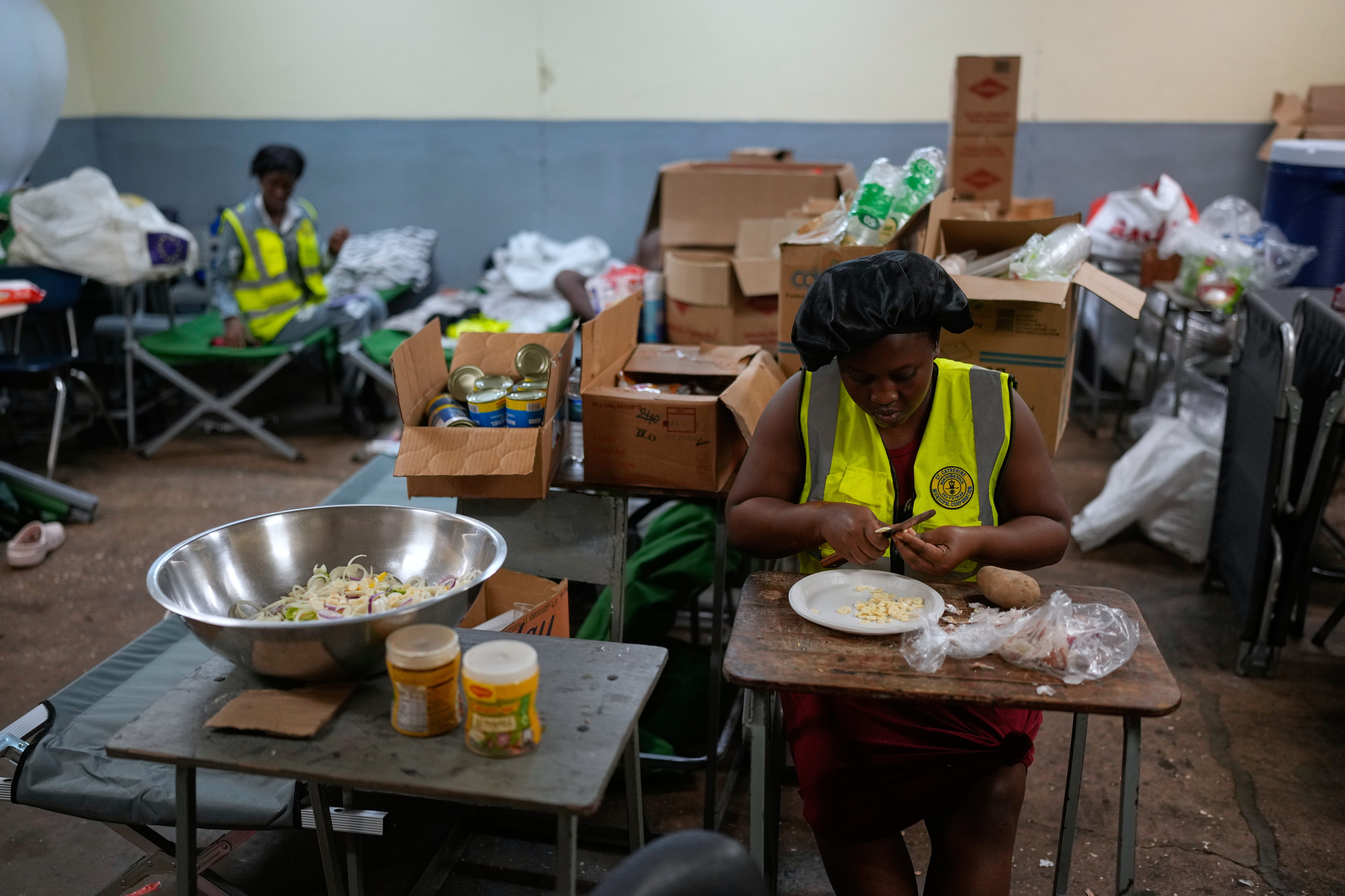 Cooks prepare meals at a shelter set up in a school ahead of Hurricane Melissa's forecast arrival in Old Harbour, Jamaica, Monday, Oct. 27, 2025. (AP Photo/Matias Delacroix)