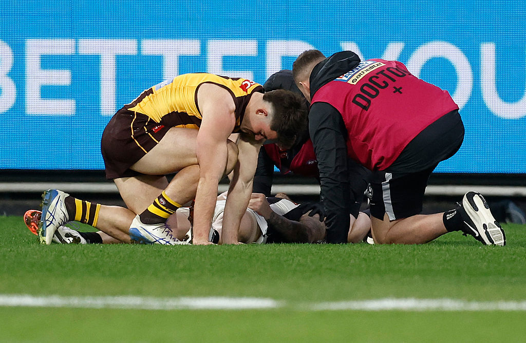 Jai Newcombe of the Hawks and Jeremy Howe of the Magpies are seen after a collision.