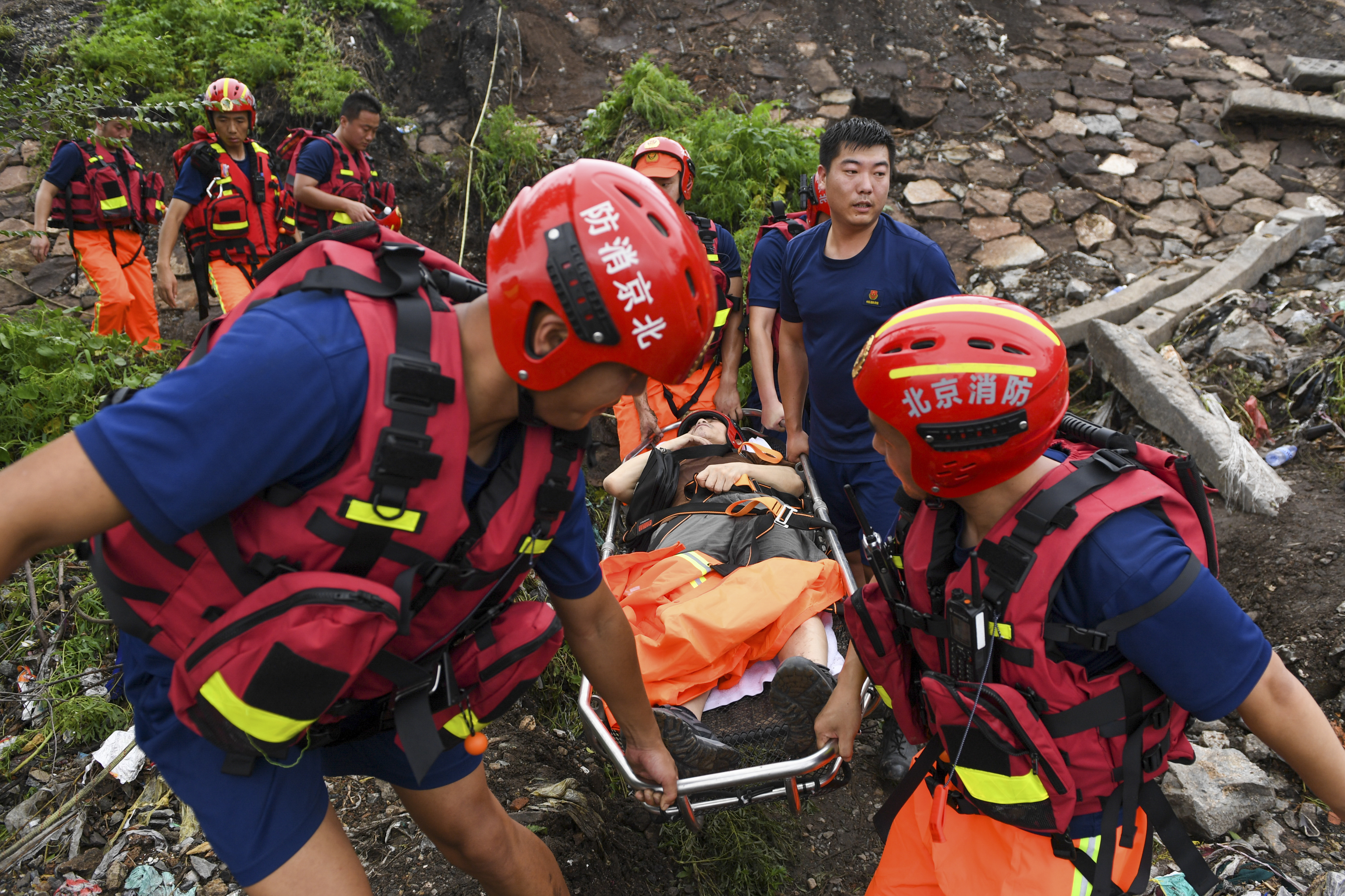 In this photo released by Xinhua News Agency, rescuers carry an injured person from a flood-hit village in Mentougou district on the outskirts of Beijing on Tuesday, Aug. 1, 2023. China's capital has recorded its heaviest rainfall in at least 140 years over the past few days after being deluged with heavy rains from the remnants of Typhoon Doksuri. (Ju Huanzong/Xinhua via AP)