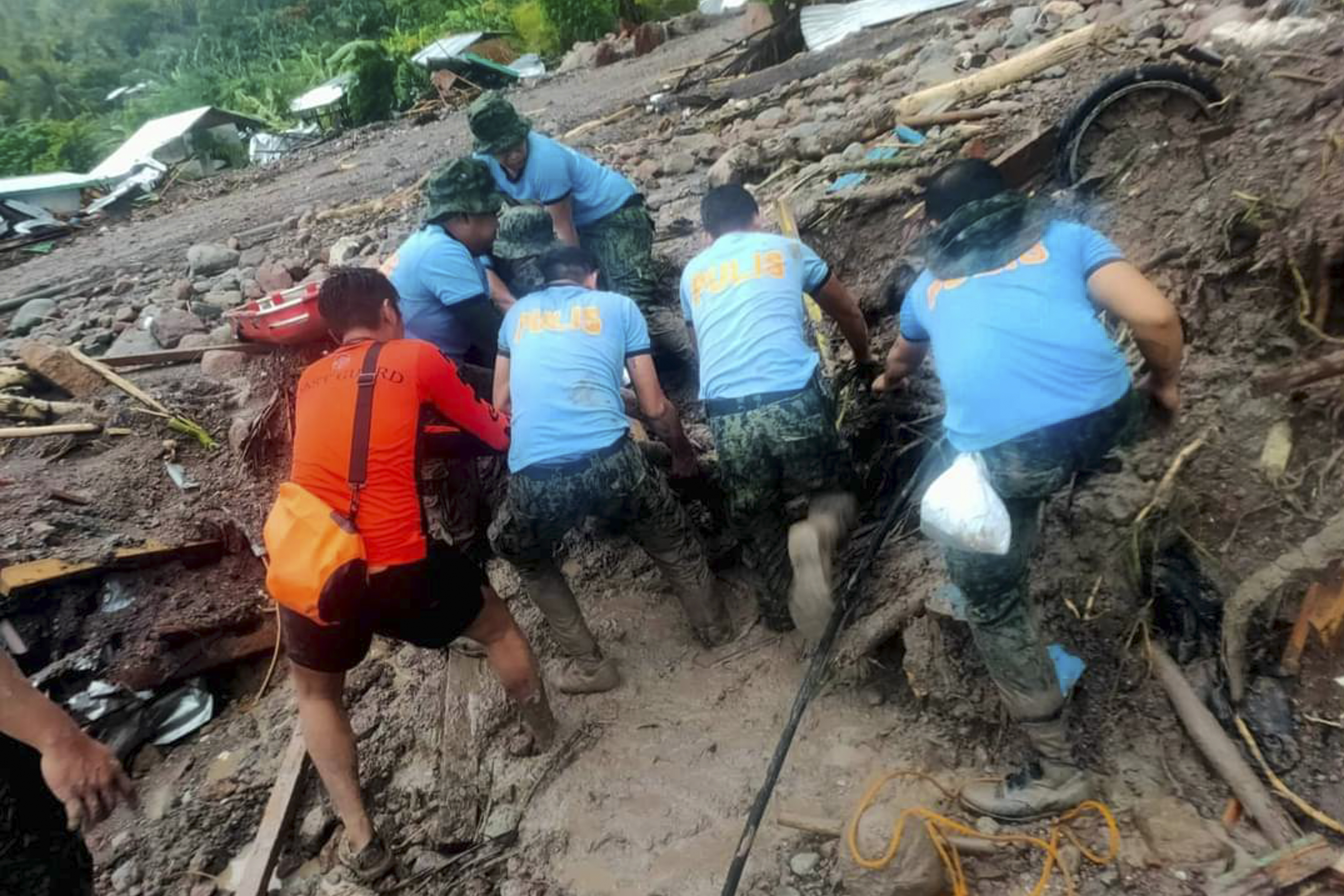 Rescuers retrieve bodies during the search and rescue operations due to landslides caused by Tropical Storm Nalgae in Barangay Kushong, Datu Odin Sinsuat, Maguindanao province, southern Philippines on Friday Oct. 28, 2022.