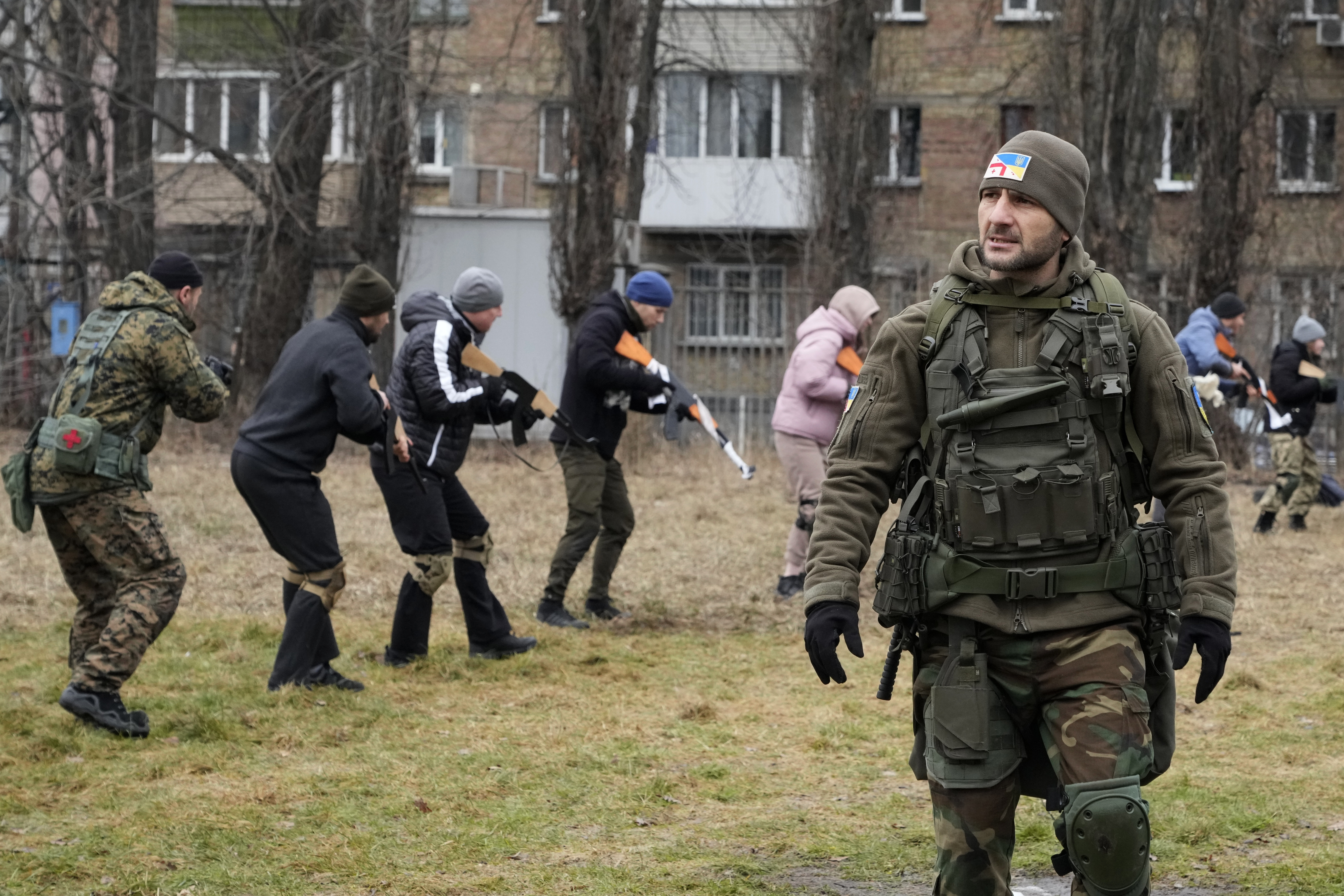 An instructor watches as civilians train with members of the Georgian Legion, a paramilitary unit formed mainly by ethnic Georgian volunteers to fight against the Russian aggression in Ukraine in 2014, in Kyiv, Ukraine, Saturday, Feb. 19, 2022.