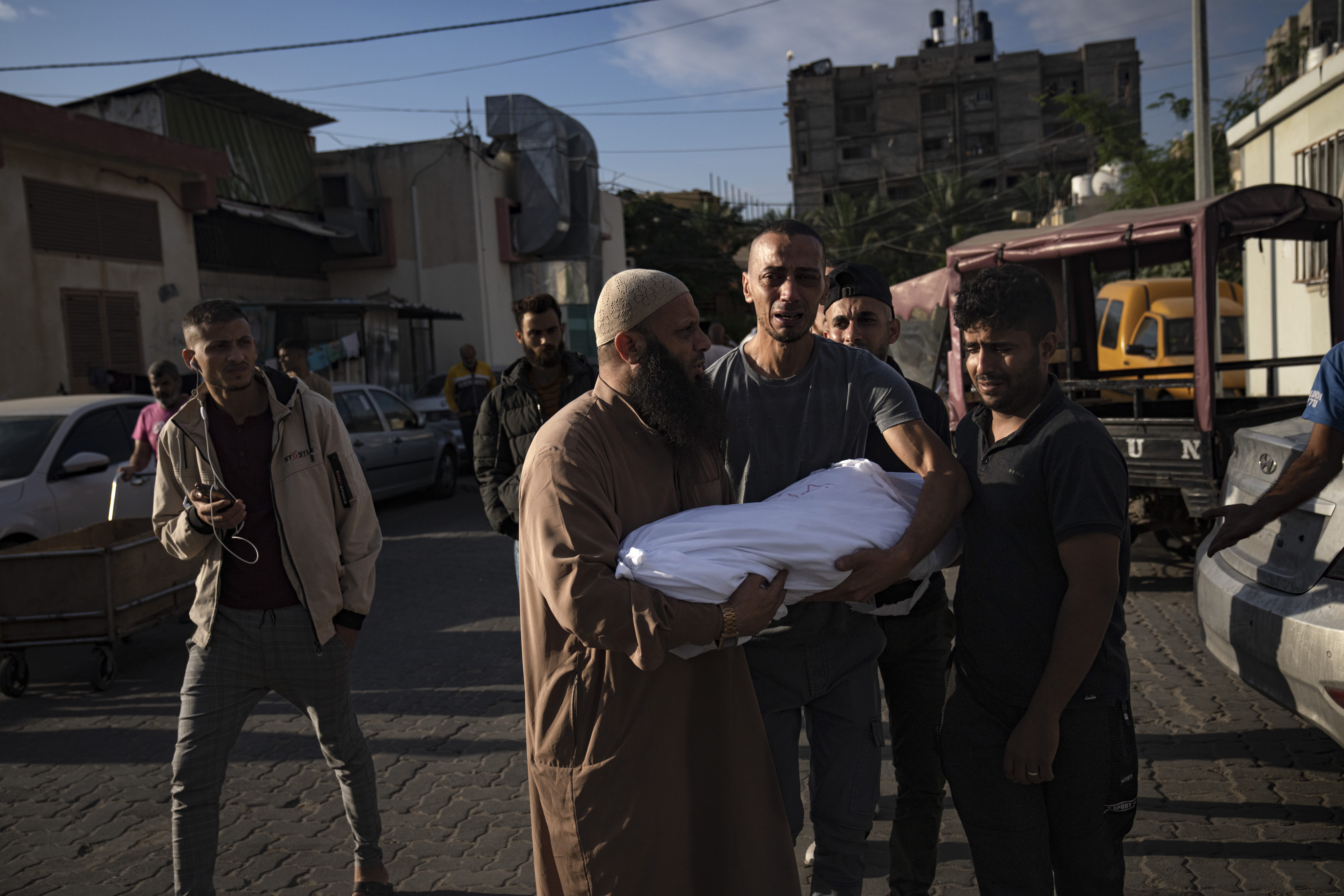 Palestinian carry a child killed in the Israeli bombardment