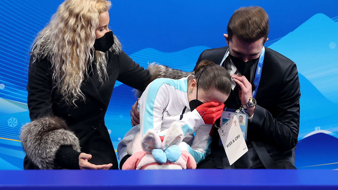 An emotional Kamila Valieva of Team ROC with choreographer Daniil Gleikhengauz (R) and coach Eteri Tutberidze (L) after the Women Single Skating Free Skating