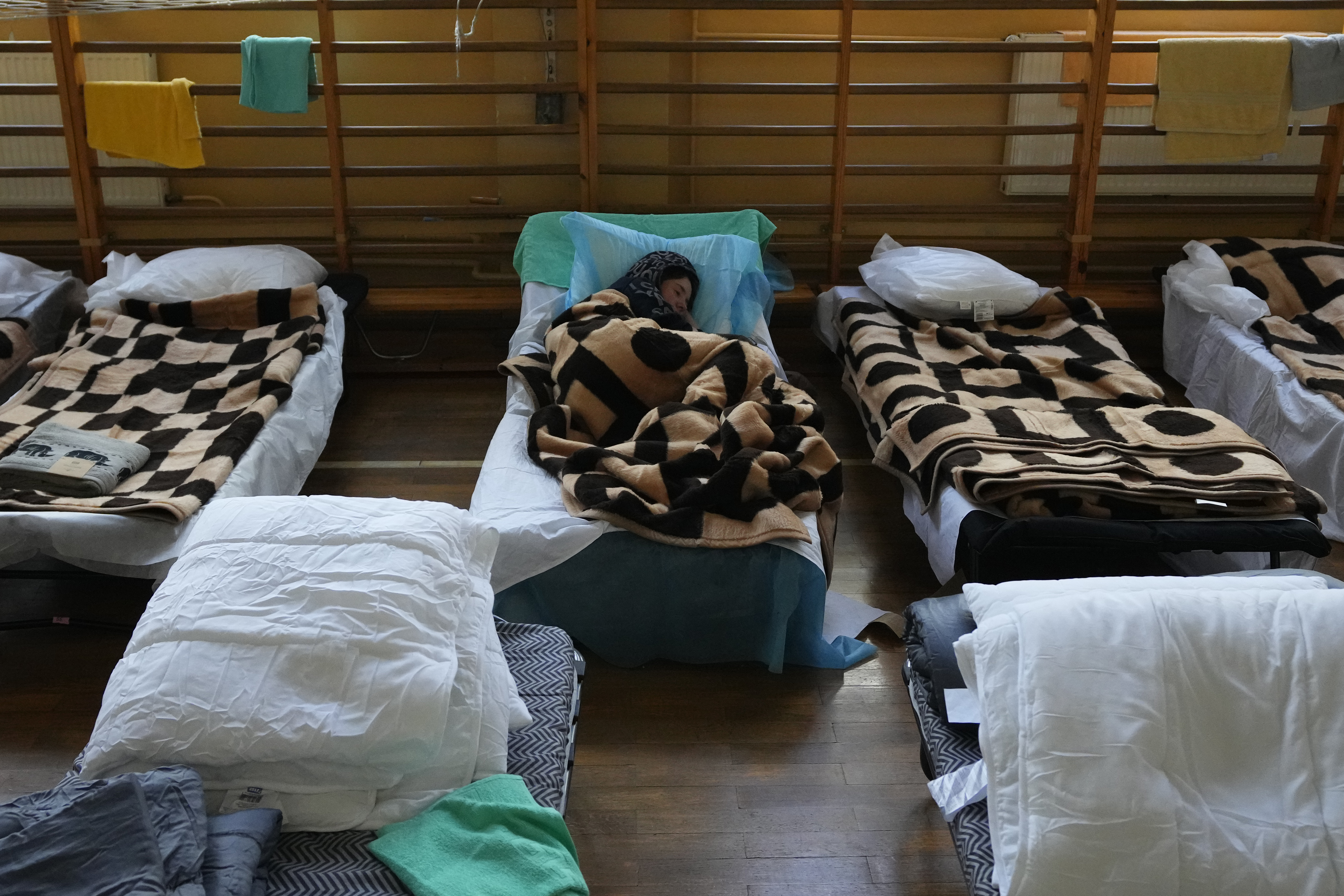 A refugee who fled the conflict from neighboring Ukraine rests in a school building in Przemysl, Poland, Saturday, Feb. 26, 2022. (AP Photo/Petr David Josek)