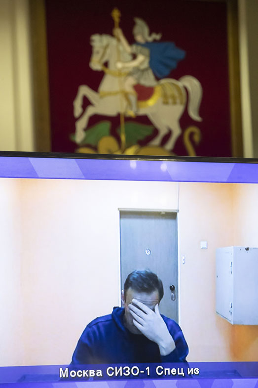 Russian opposition leader Alexei Navalny appears on a TV screen during a live session with the court during a hearing of his appeal in a court in Moscow, Russia, Thursday, Jan. 28, 2021
