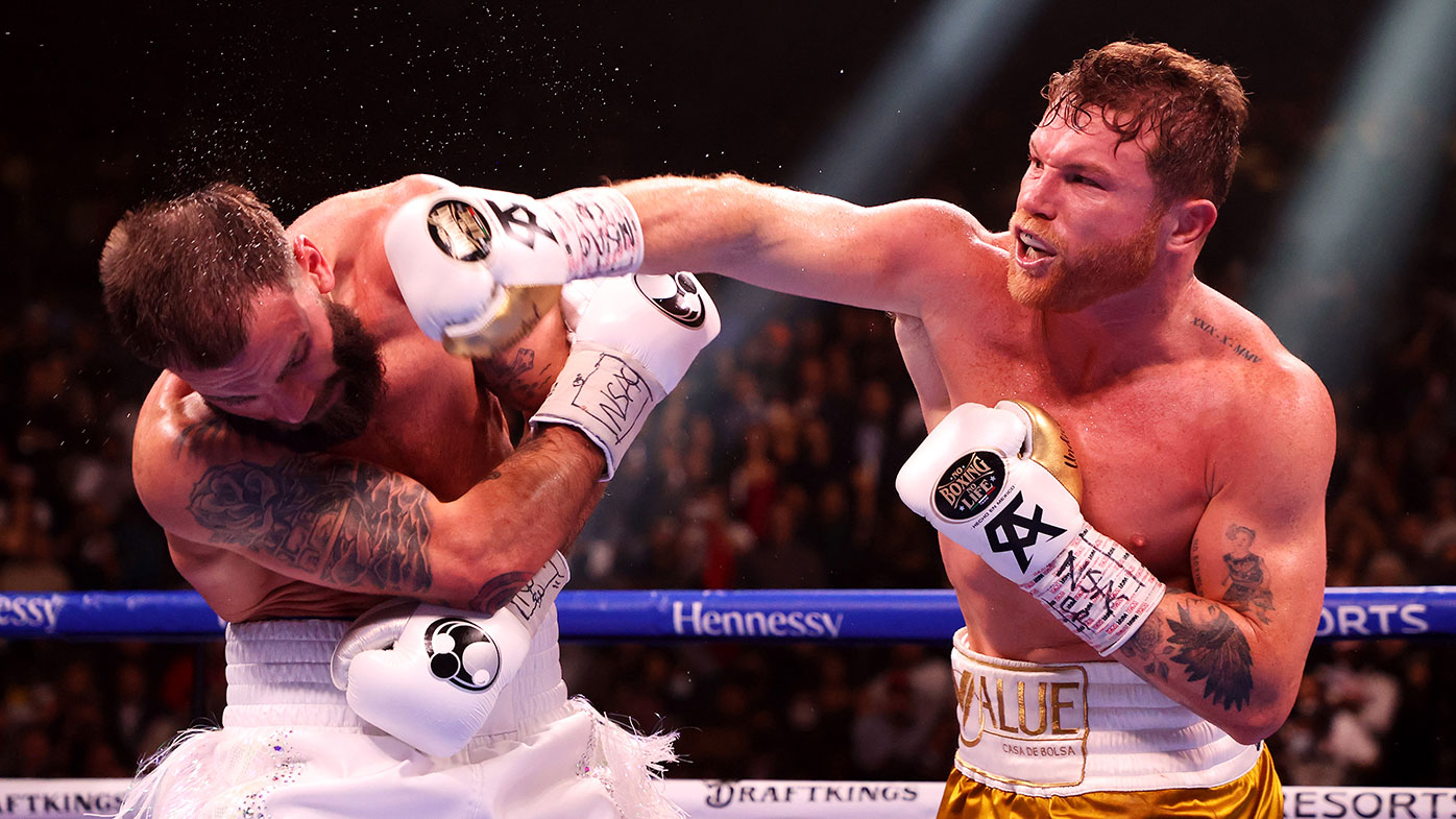 Canelo Alvarez (R) punches Caleb Plant during their championship bout