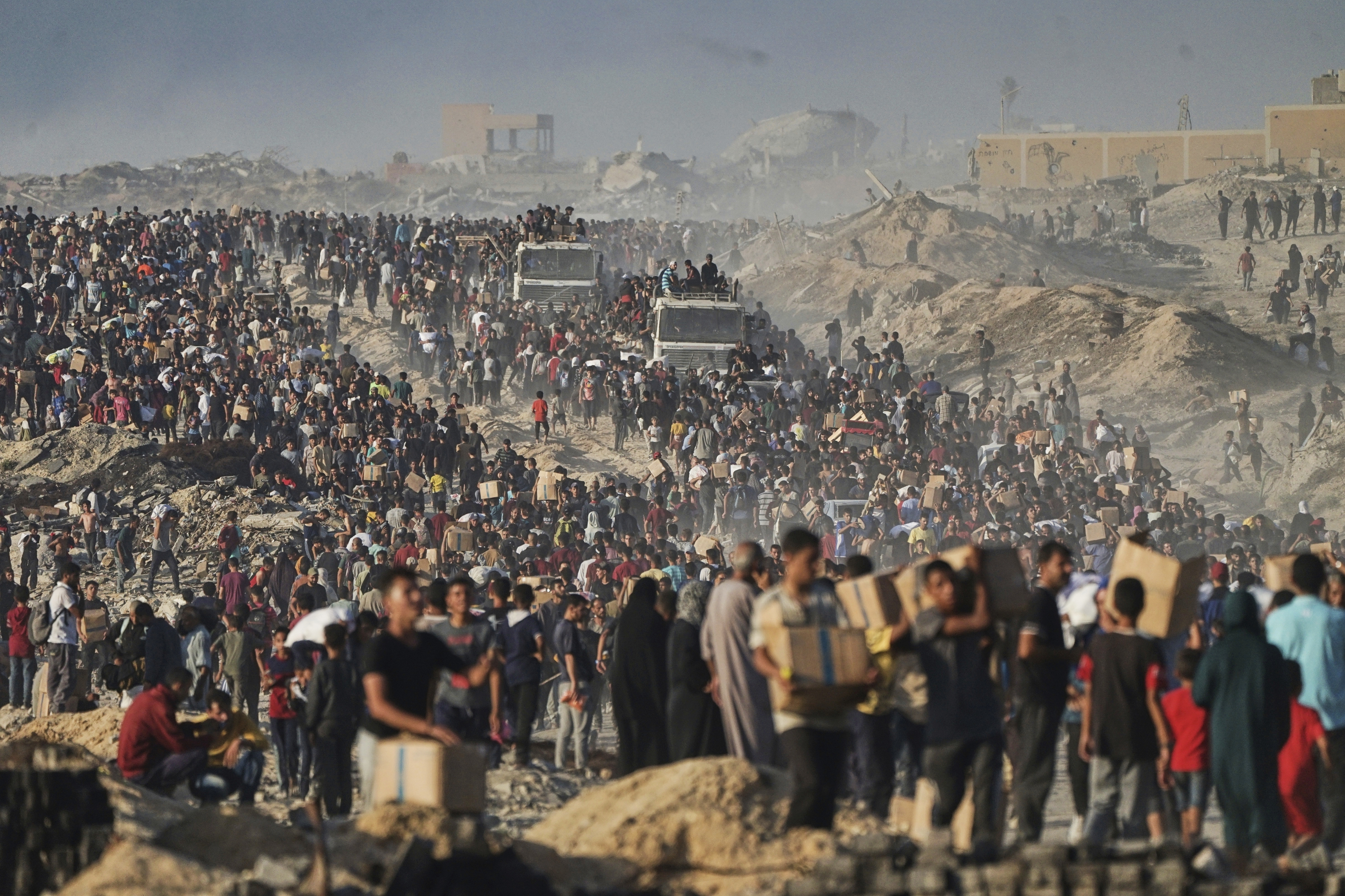 FILE - Palestinians carry sacks and boxes of food and humanitarian aid, unloaded from a World Food Program convoy that was heading to Gaza City in the northern Gaza Strip, Monday, June 16, 2025. (AP Photo/Jehad Alshrafi, file)