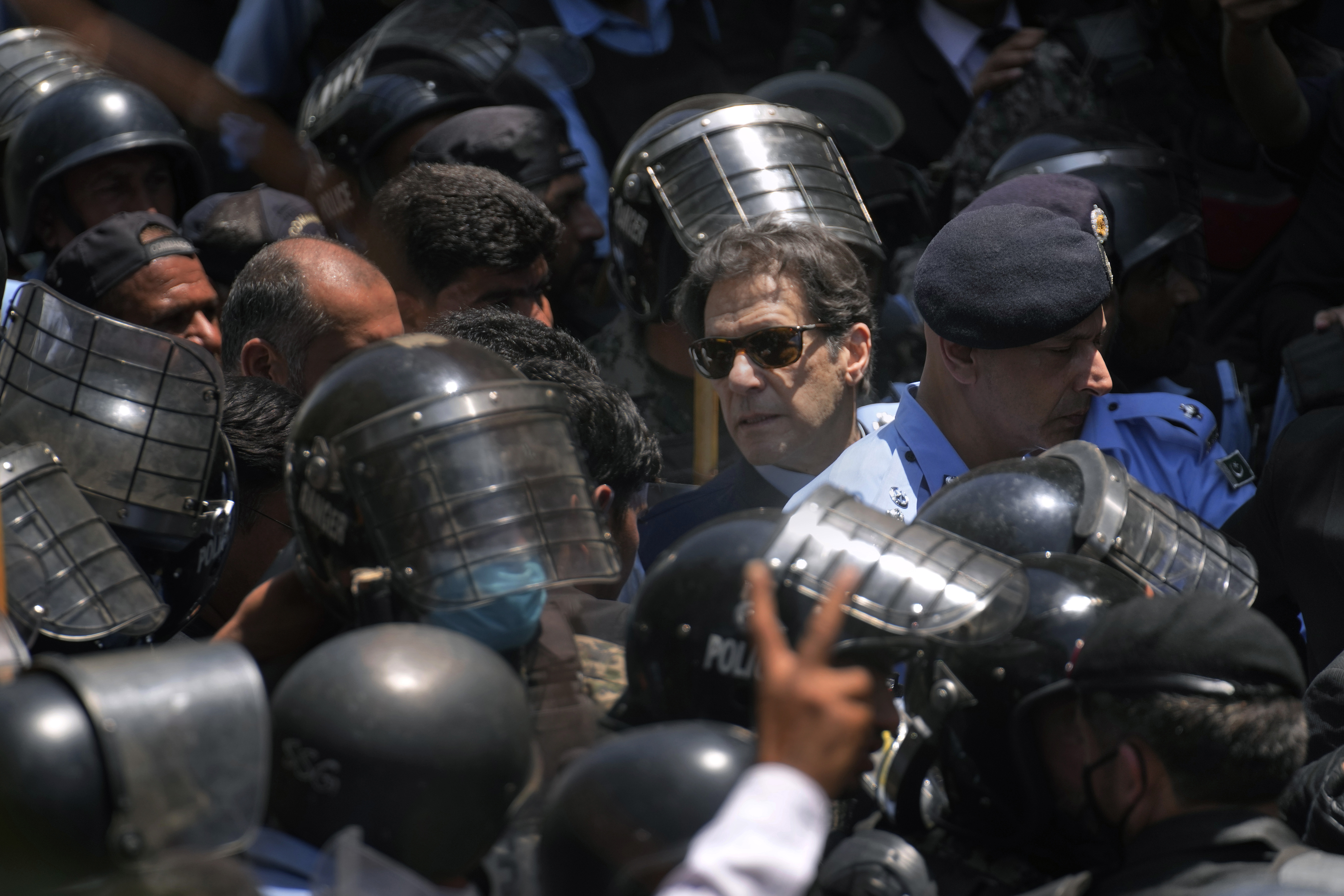 Pakistan's former Prime Minister Imran Khan, centre, is escorted by police officers as he arrives to appear in a court, in Islamabad, Pakistan, Friday, May 12, 2023.