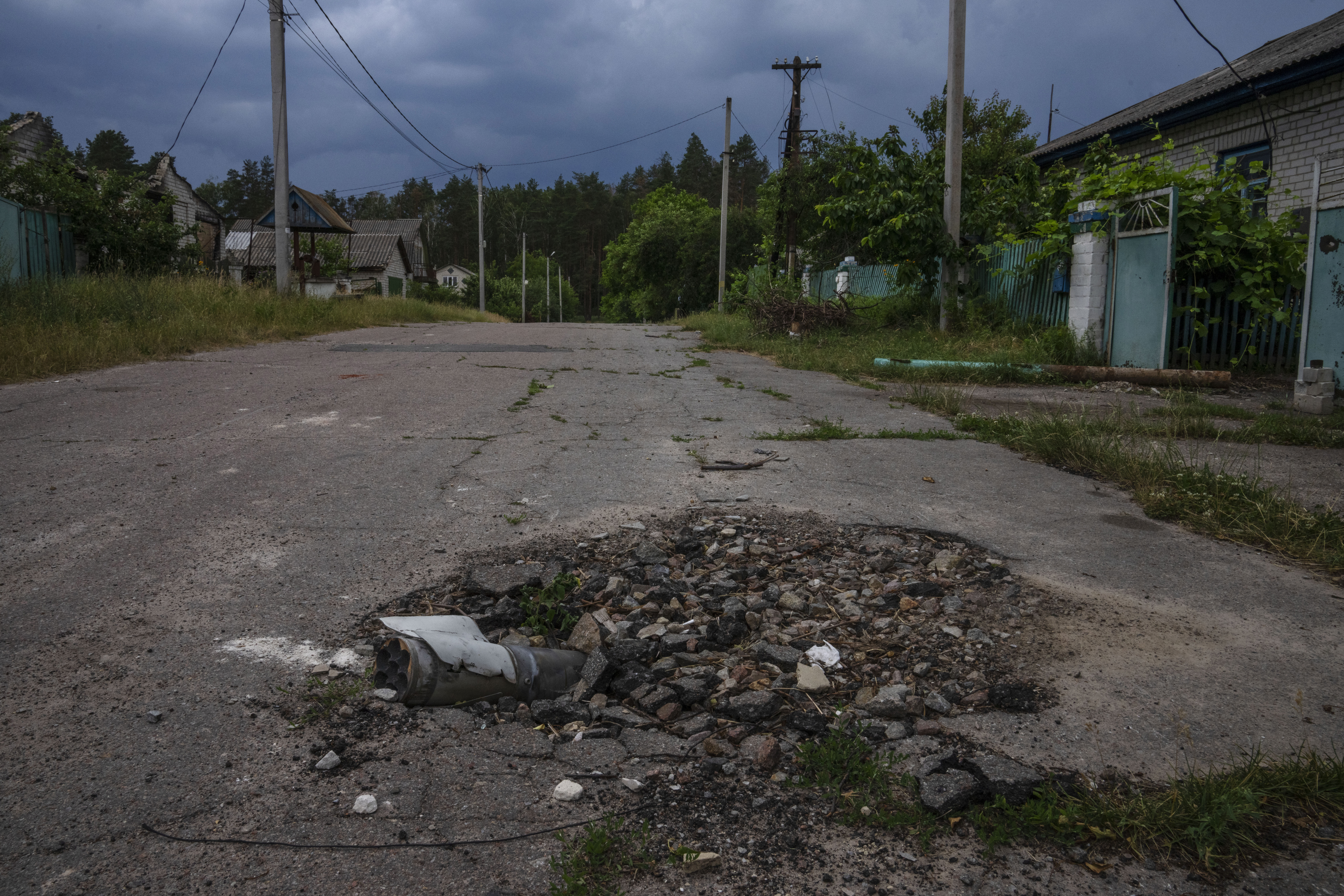 A part of a mortar shell lays on a road in Yahidne village, as civilians rebuild their homes after being destroyed by Russian strikes.