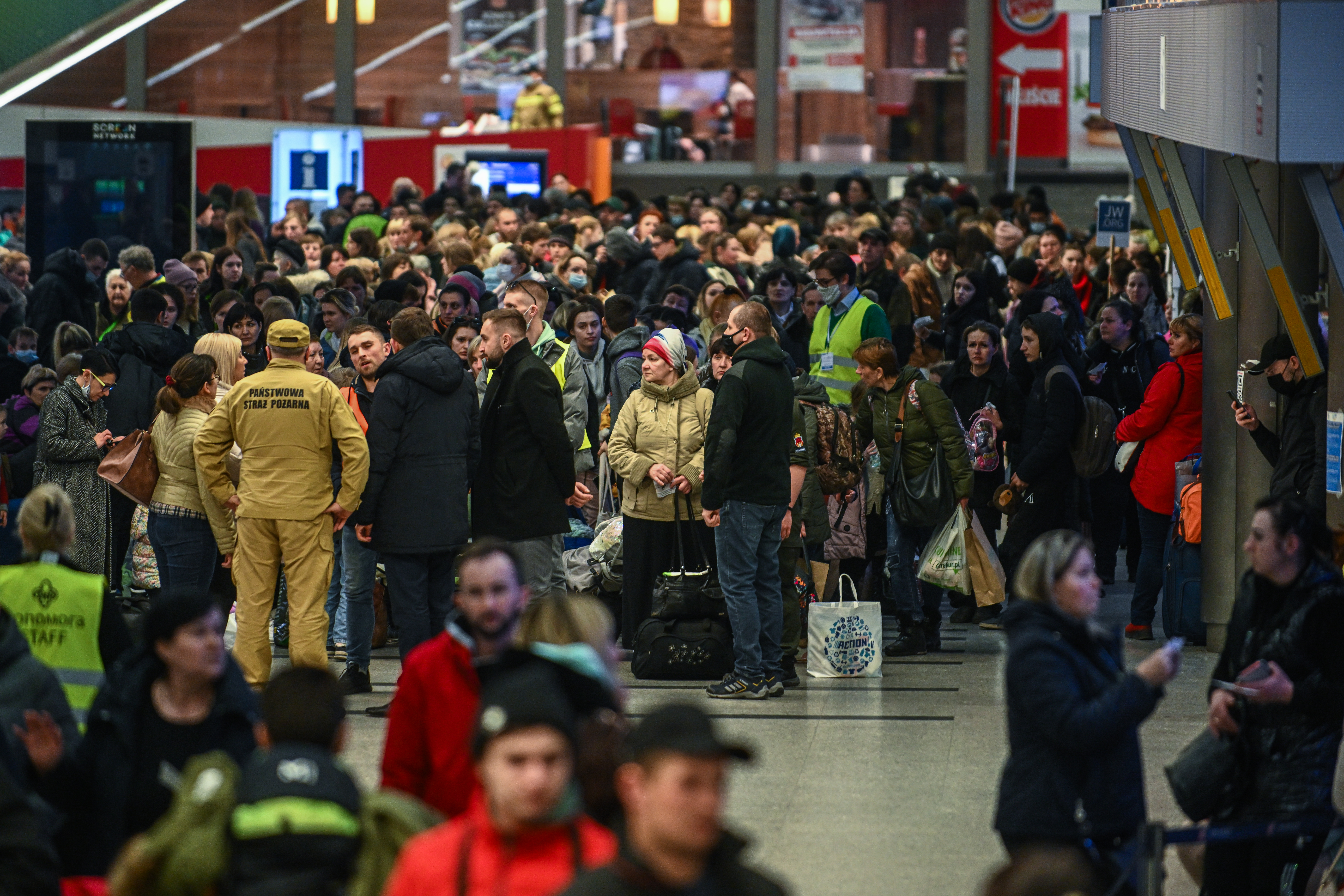People who fled the war in Ukraine walk towards a humanitarian train in Krakow in Poland, to relocate as refugees to Berlin. 