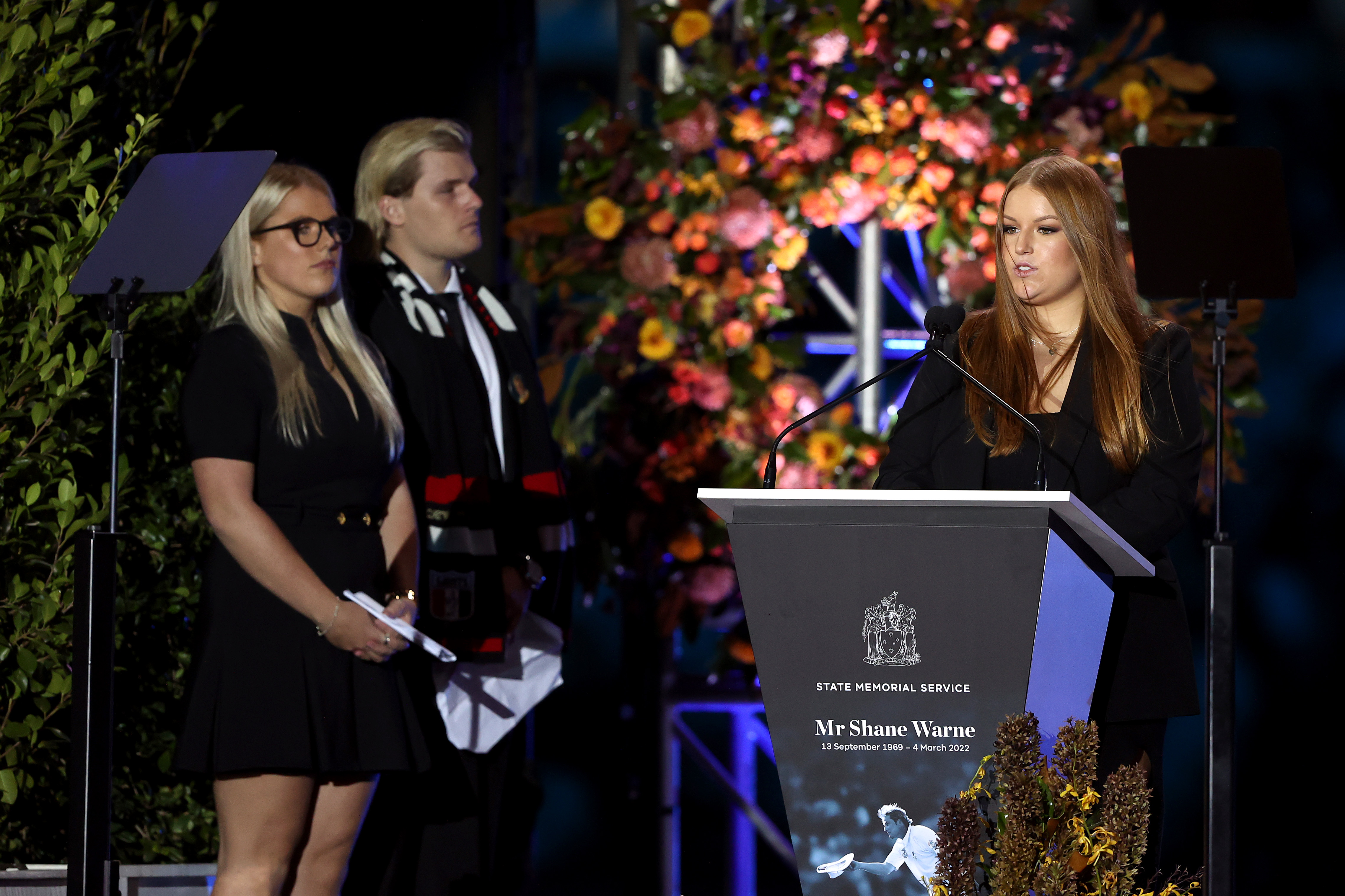 Summer Warne speaks on stage alongside Jackson Warne and Brooke Warne during the state memorial service for former Australian cricketer Shane Warne at the Melbourne Cricket Ground on March 30, 2022 in Melbourne, Australia.