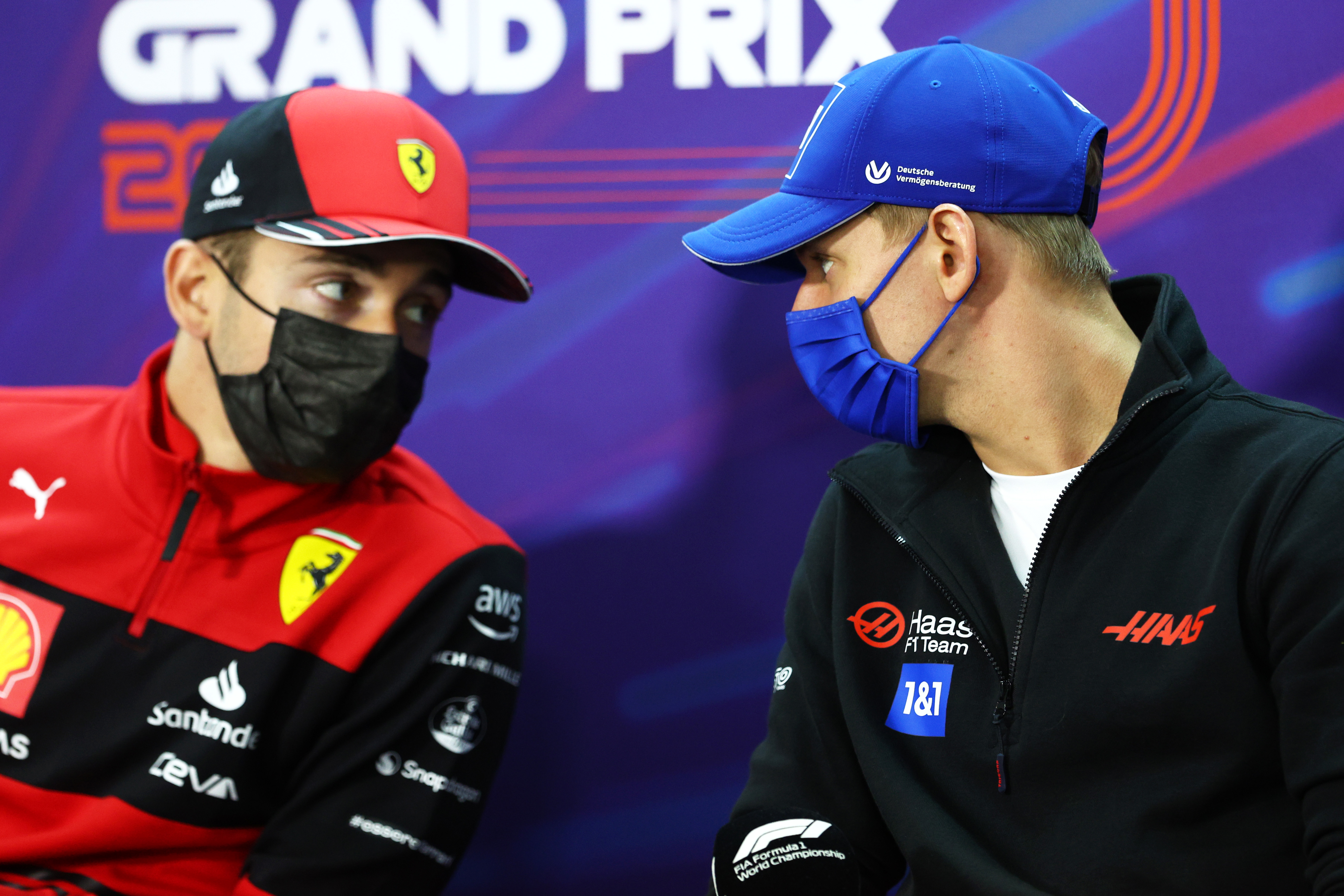 Haas driver Mick Schumacher talks with Ferrari's Charles Leclerc.