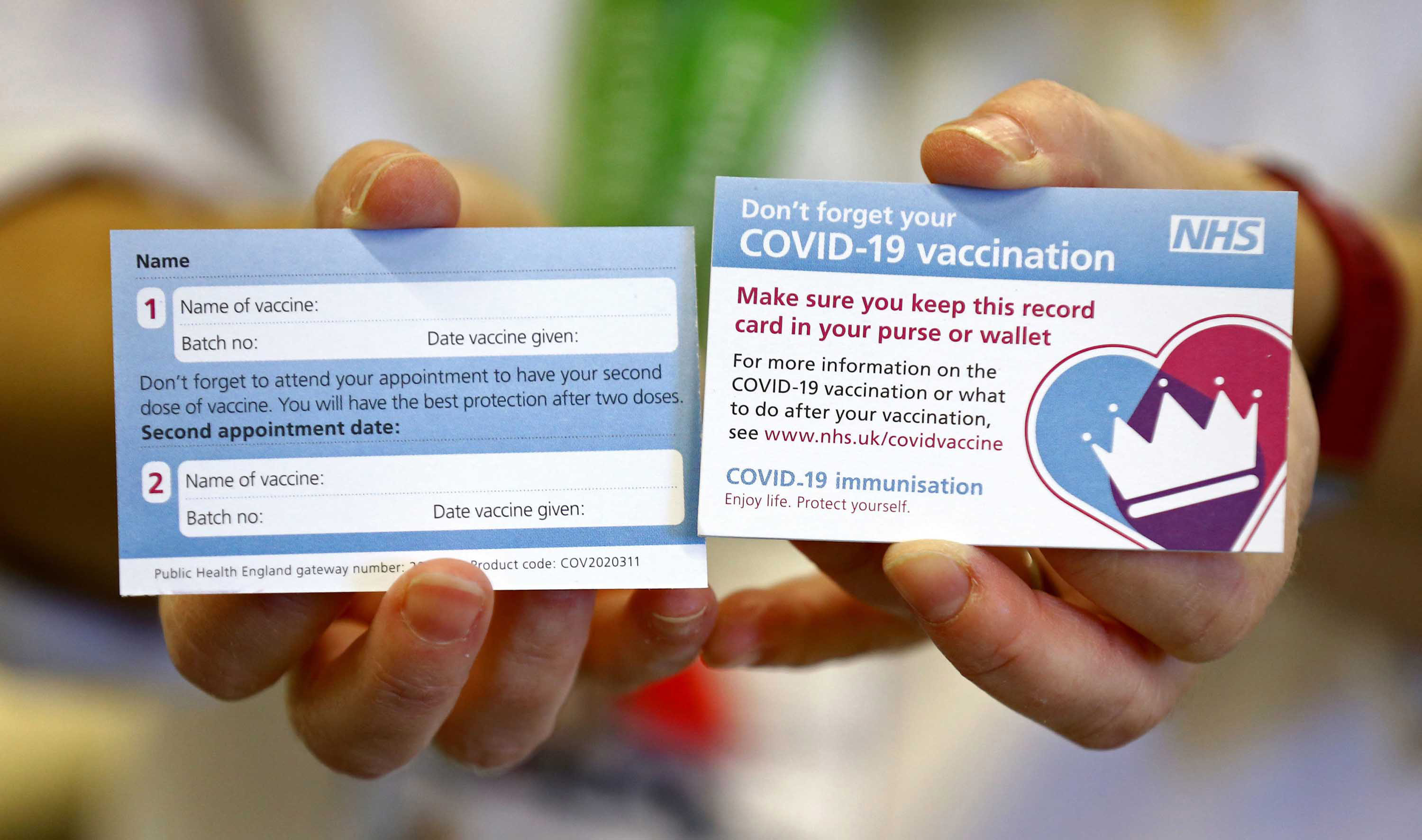 A model holds a card which will be given to patients following their vaccination for COVID-19 at Croydon University Hospital in south London on December 5, 2020, where the first batch of COVID-19 vaccinations has been delivered to the area.
