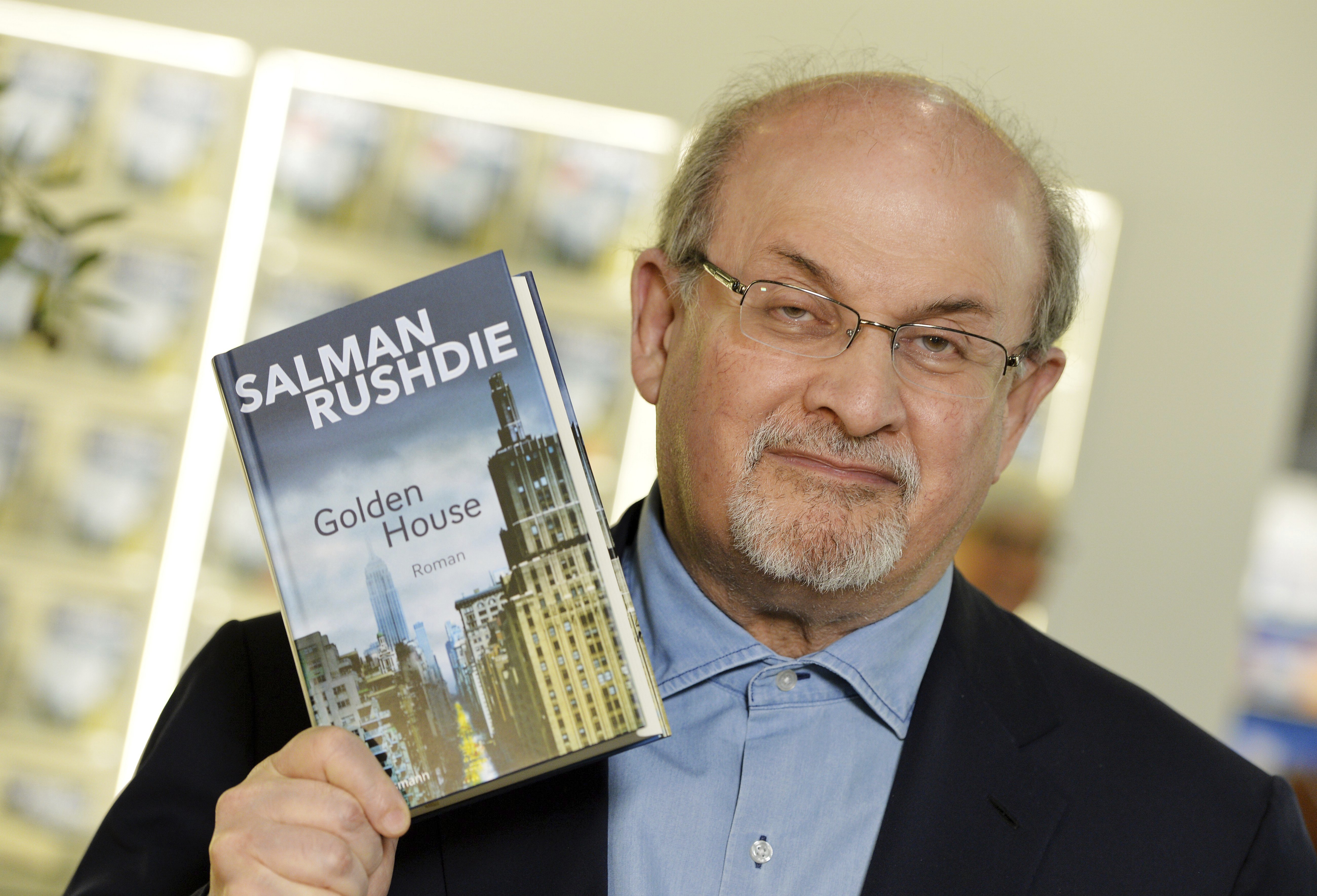 Author Salman Rushdie,shows a new book as he visits the book fair in Frankfurt, Germany, Thursday, Oct. 12, 2017.