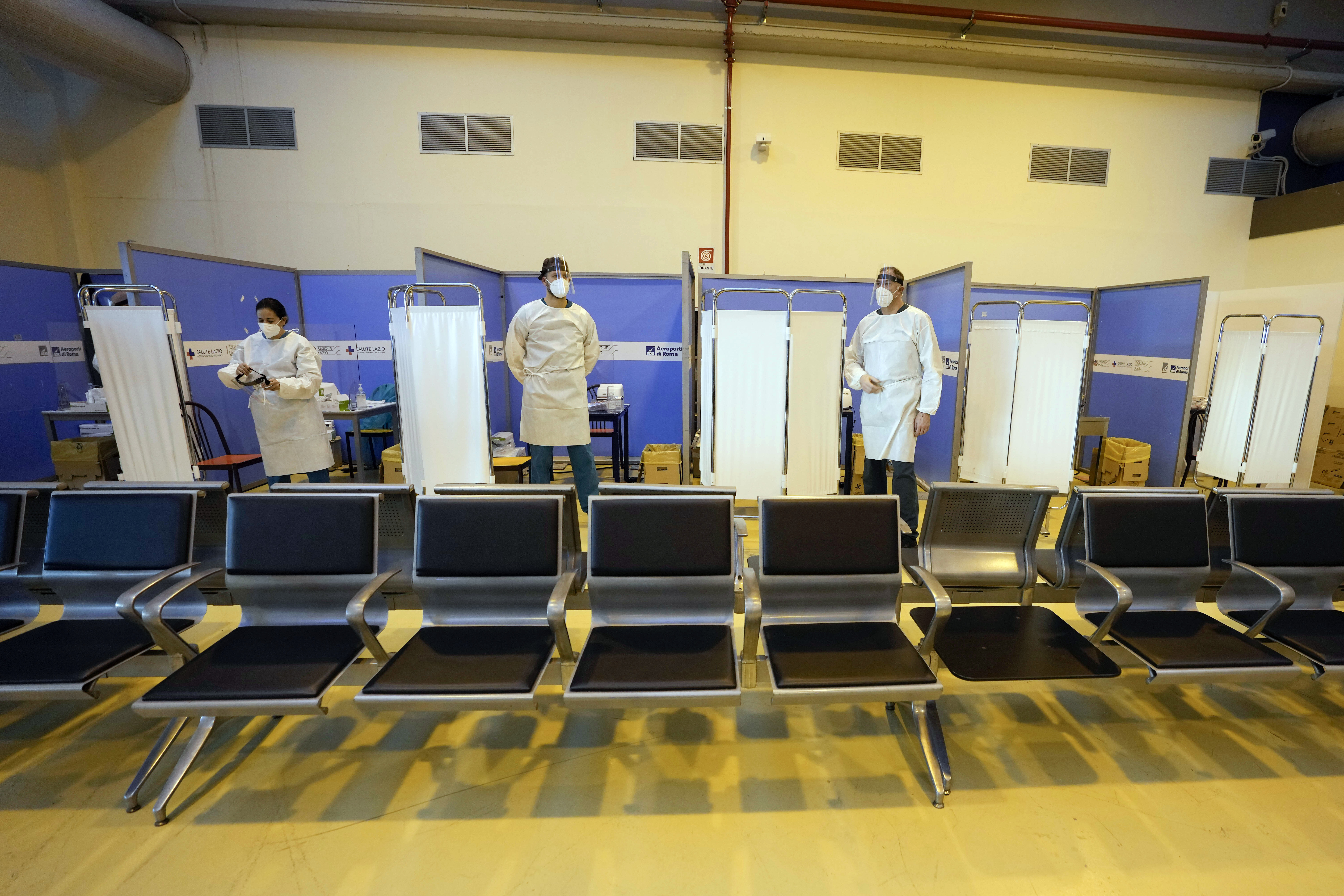 Medical personnel wait for passengers coming with an Air China flight from Guangzhou, China, in a COVID-19 testing area set at Rome's Leonardo da Vinci international airport in Fiumicino, Thursday, December 29, 2022 after Italy made coronavirus tests mandatory for all airline passengers arriving from China. 
