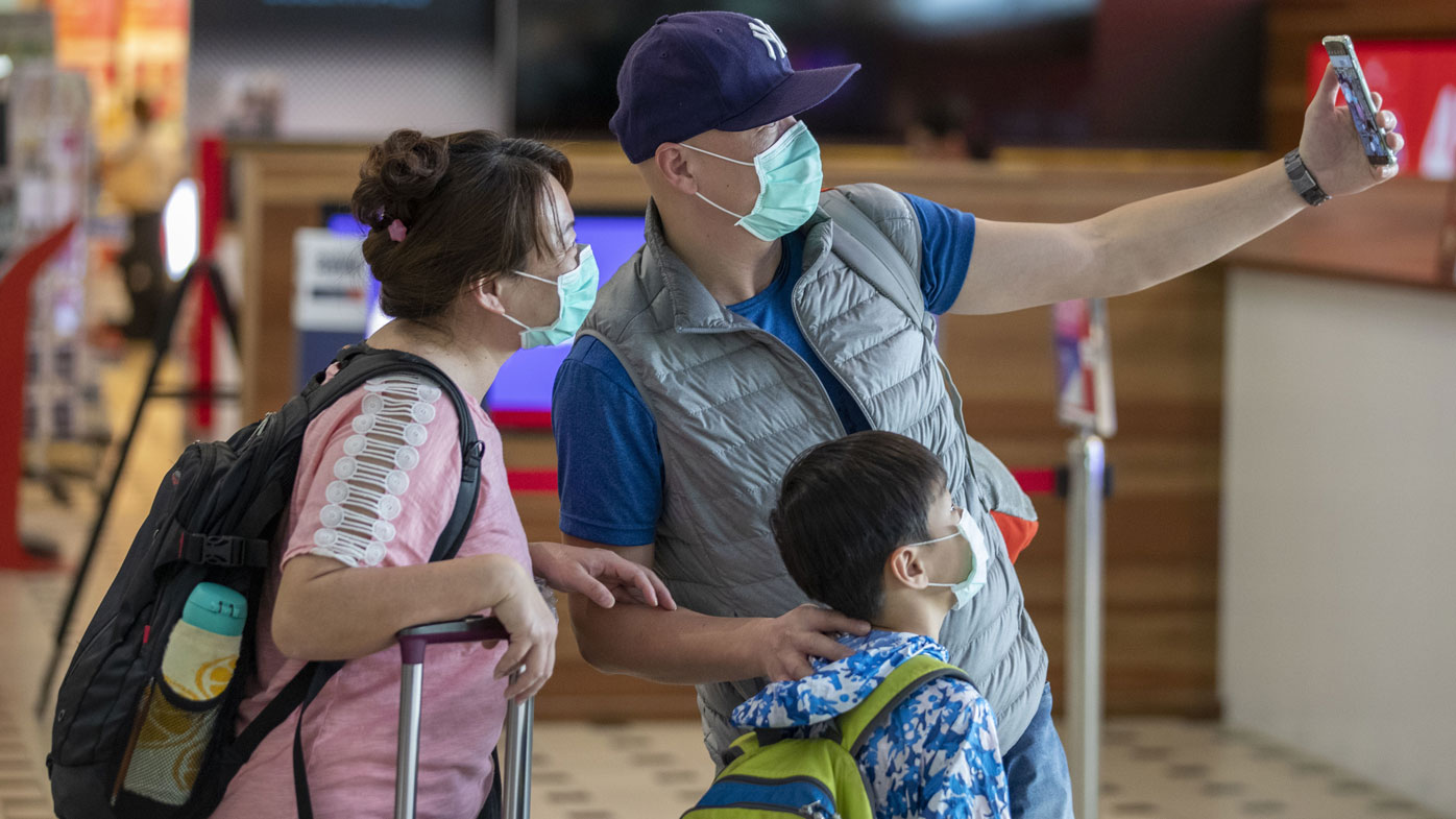 People wearing protective face masks to protect themselves from Coronavirus are seen at Brisbane International Airport in Brisbane, Friday, January 31, 2020