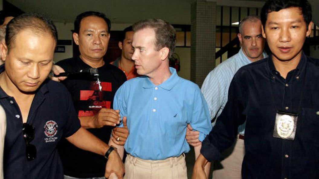 Thai police escort American teacher John Mark Karr at the Thai Immigration Department in Bangkok on August 17, 2006. At the time, Karr was a suspect in the JonBenét Ramsey case.