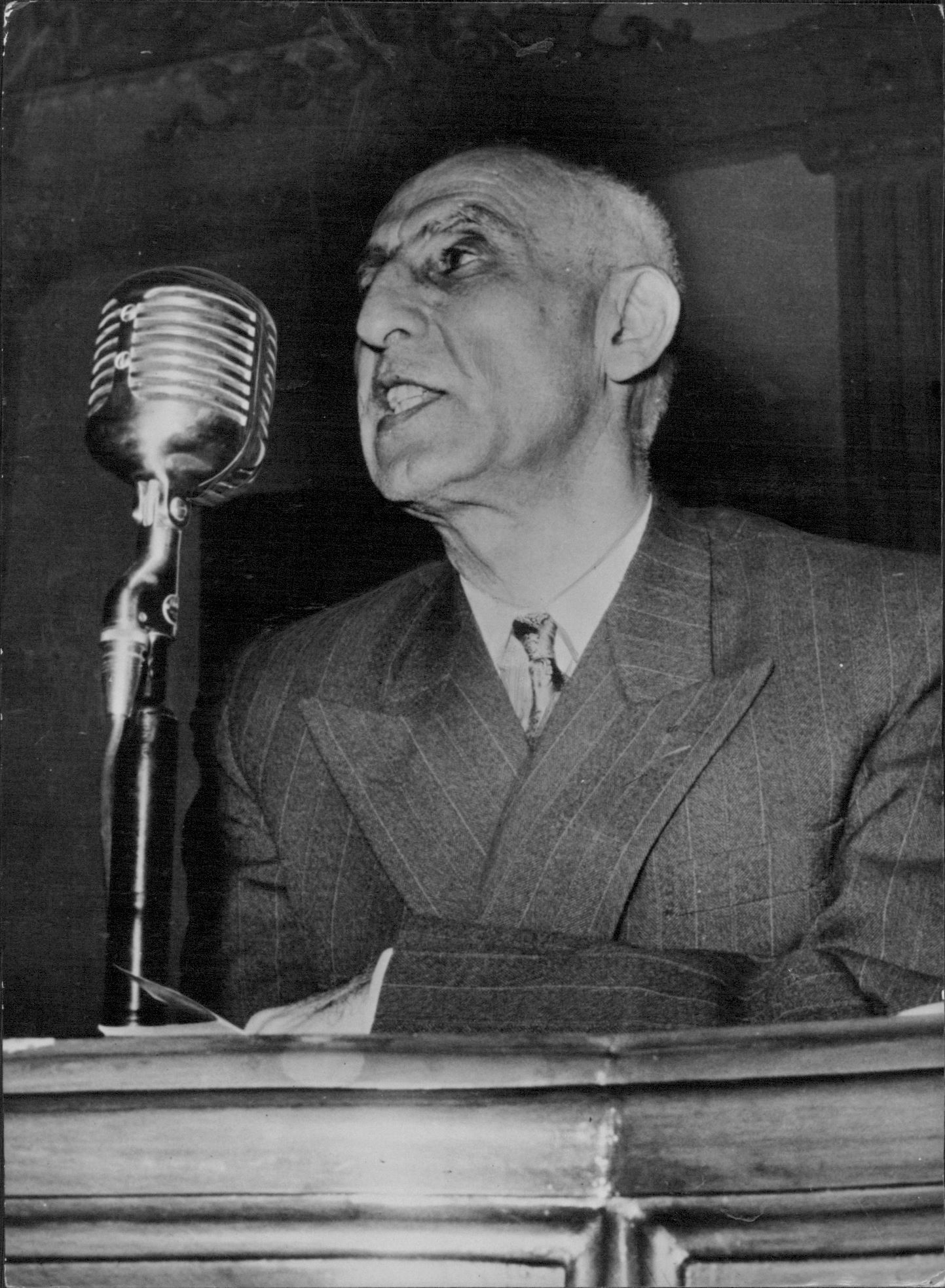 Persian Politicians; Dr. Muhammad Mossadeq -- Persia's Prime Minister and Minister of National Defence, photographed whilst delivering an impassioned radio address. June 10, 1953. 