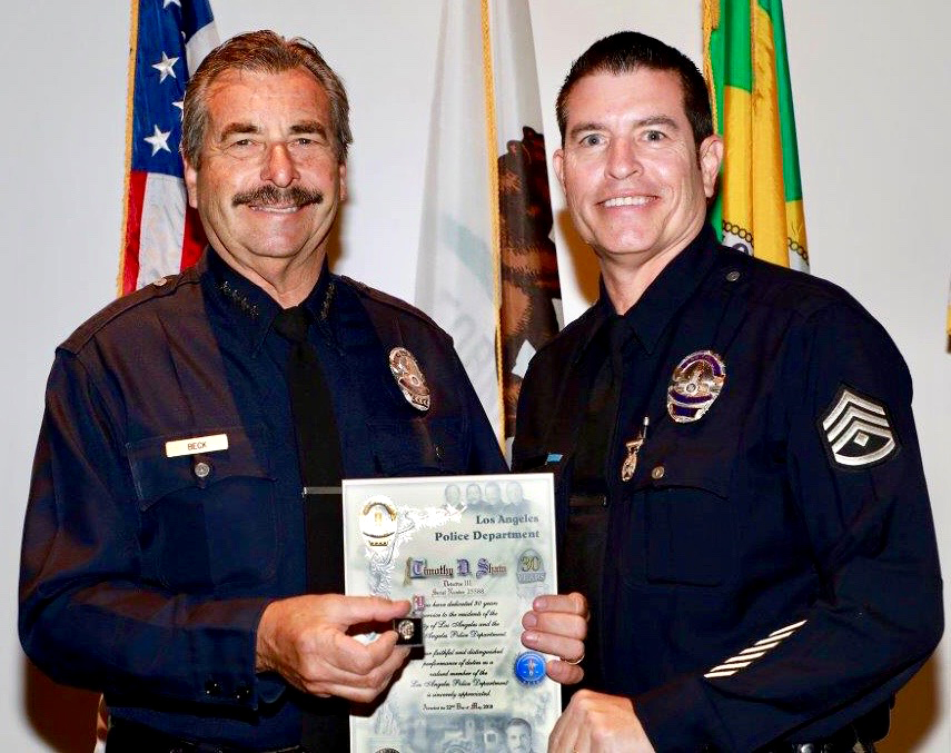 Detective Tim Shaw is awarded his 30-year service pin from then Los Angeles Police Department chief Charlie Beck.