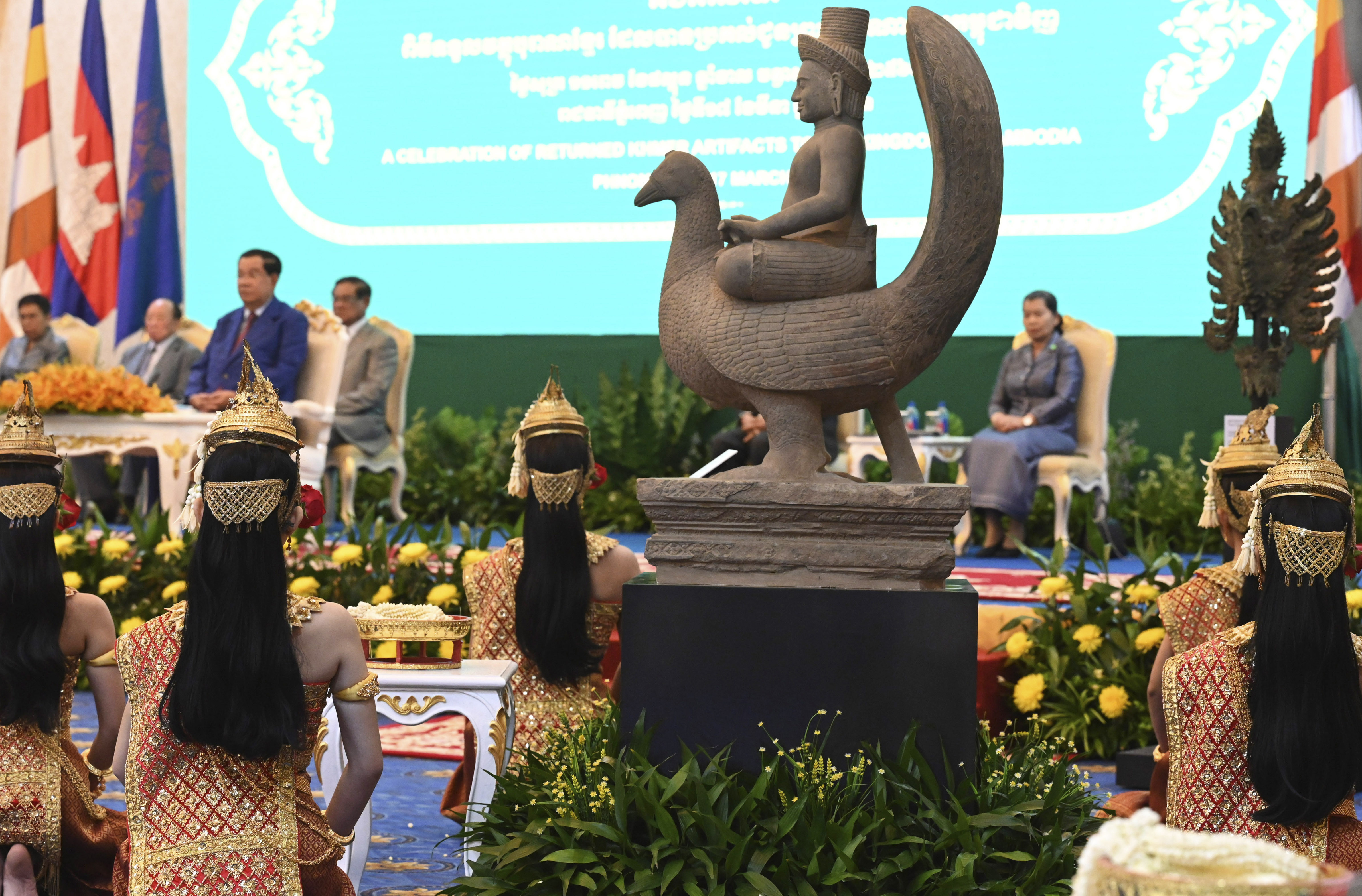 The 10th-century statue of Skanda atop a peacock, upper, is displayed during a handing over ceremony at Peace Palace, in Phnom Penh, Cambodia, Friday, March 17, 2023. 