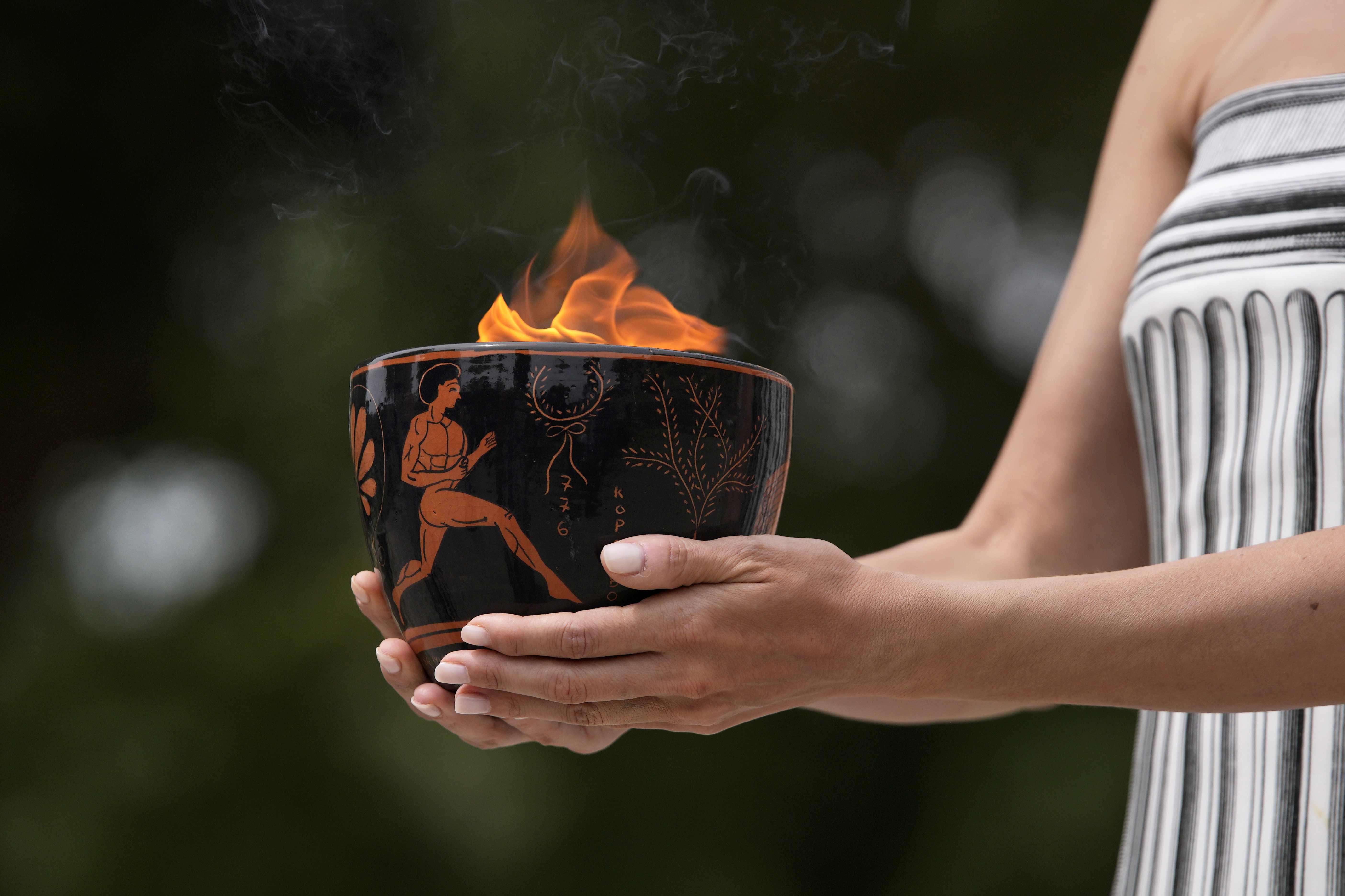 Performers take part in the official ceremony of the flame lighting for the Paris Olympics