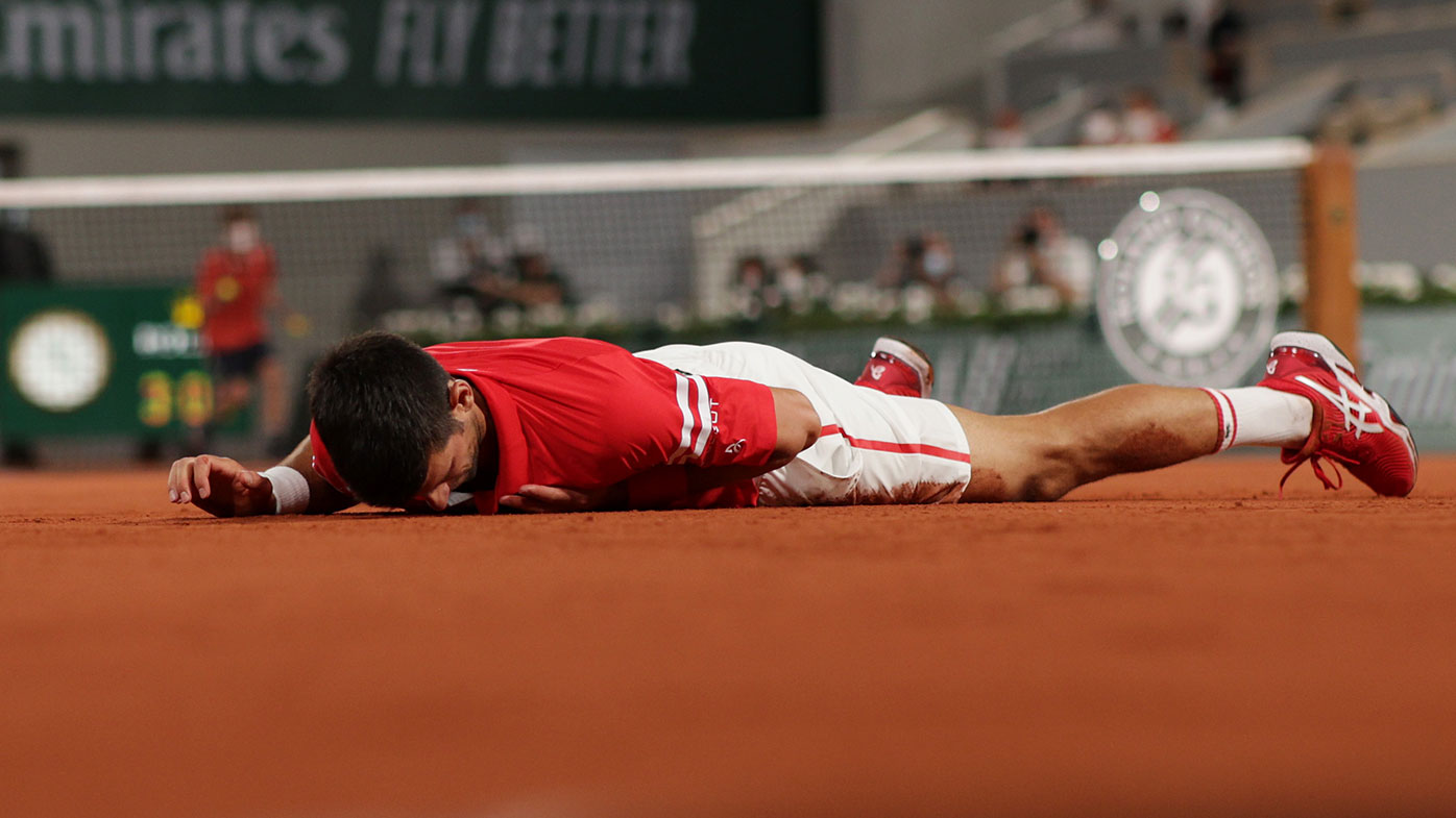 Novak Djokovic falls during his Roland-Garros quarter final win over Matteo Berrettini.
