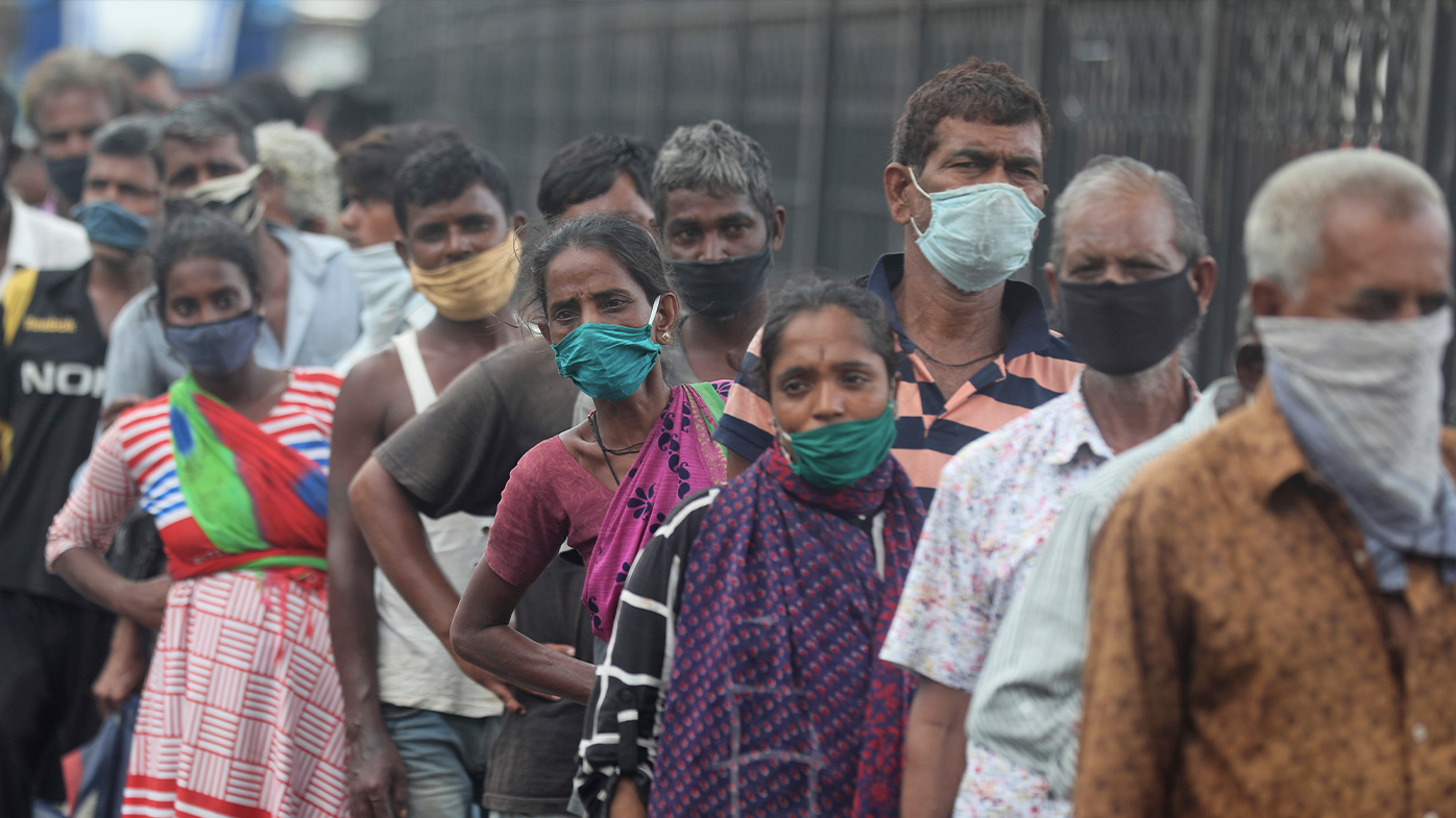 Homeless people stand in a queue during a food distribution in Mumbai, India, Saturday, June 20, 2020. (AP Photo/Rafiq Maqbool)
