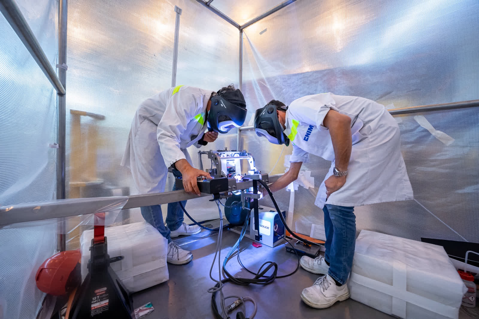 Workers preforming precision welding on superconductors during construction at ITER. 