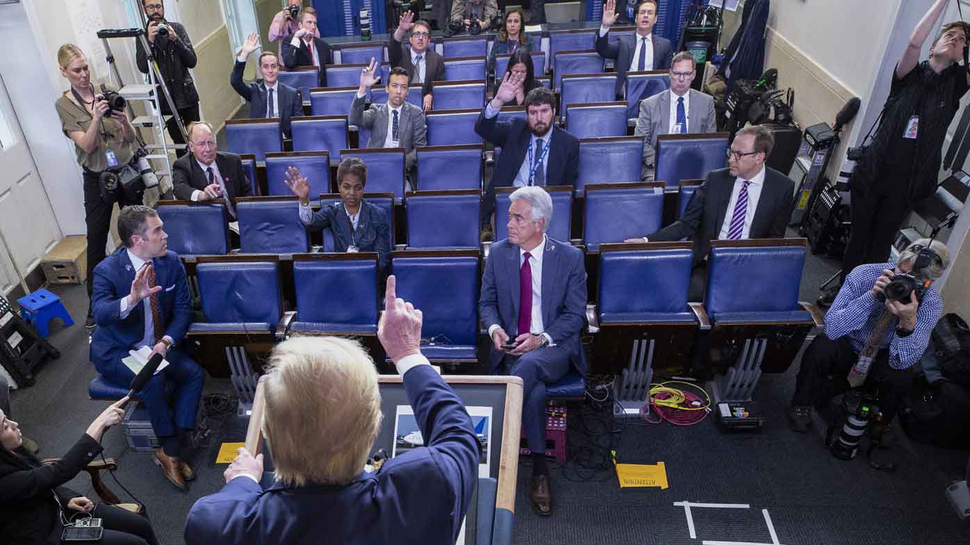 Donald Trump takes questions from a sparsely attended White House press conference. Journalists are required to be seating well apart from each other.