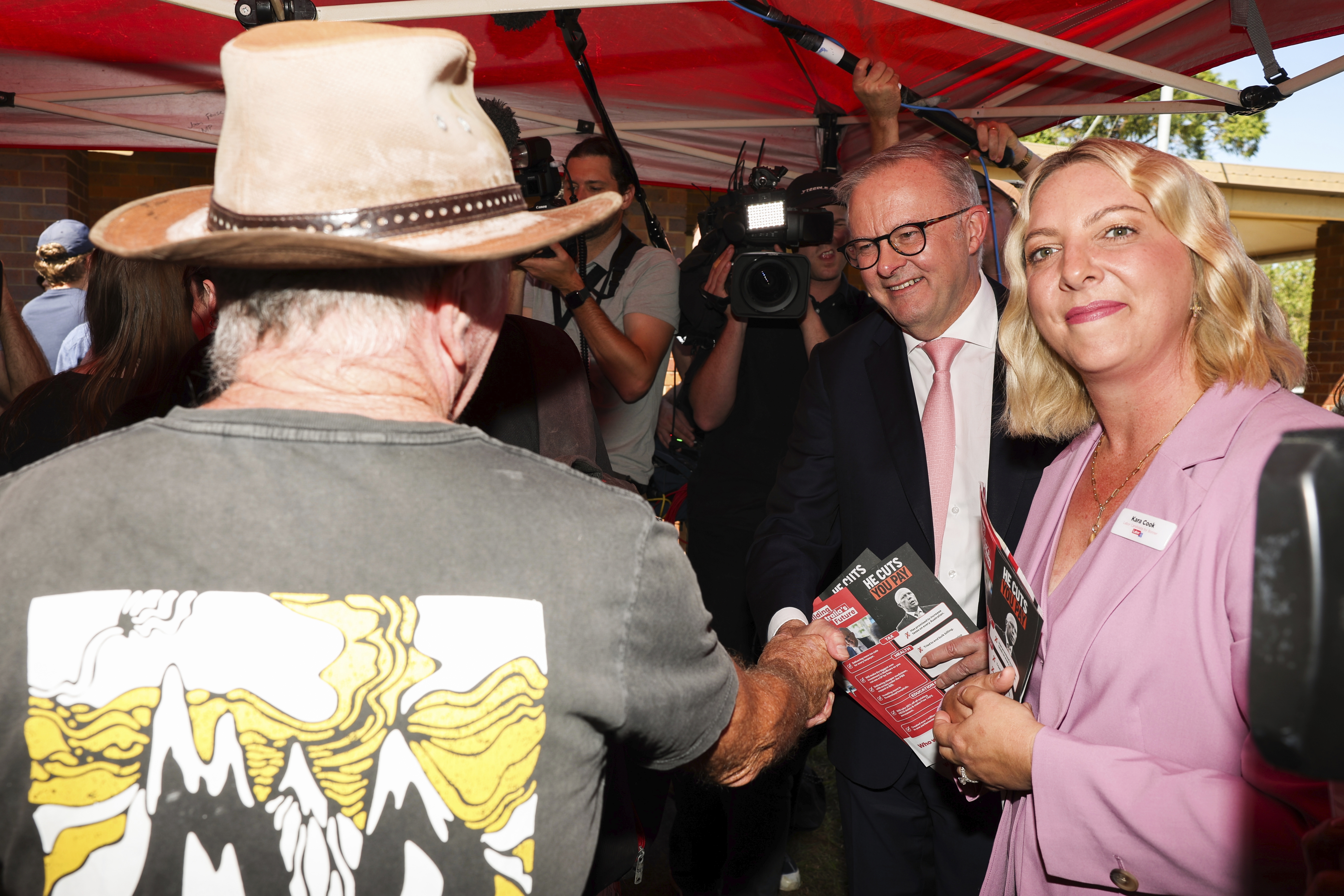 Prime Minister Anthony Albanese with Labor candidate for Bonner, Kara Cook, and a baby during a visit to a an early voting polling place, in the electorate of Bonner, in Wynnum
