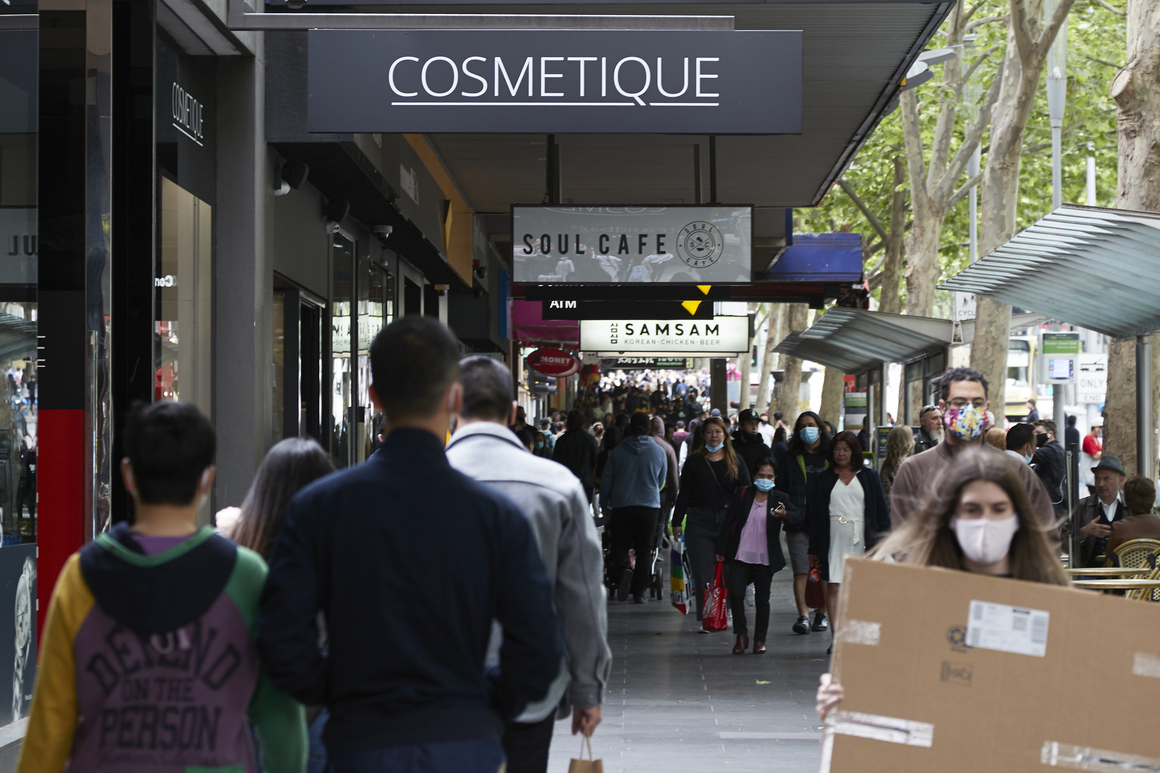 Shoppers walk past stores on Swanston Street in Melbourne. 