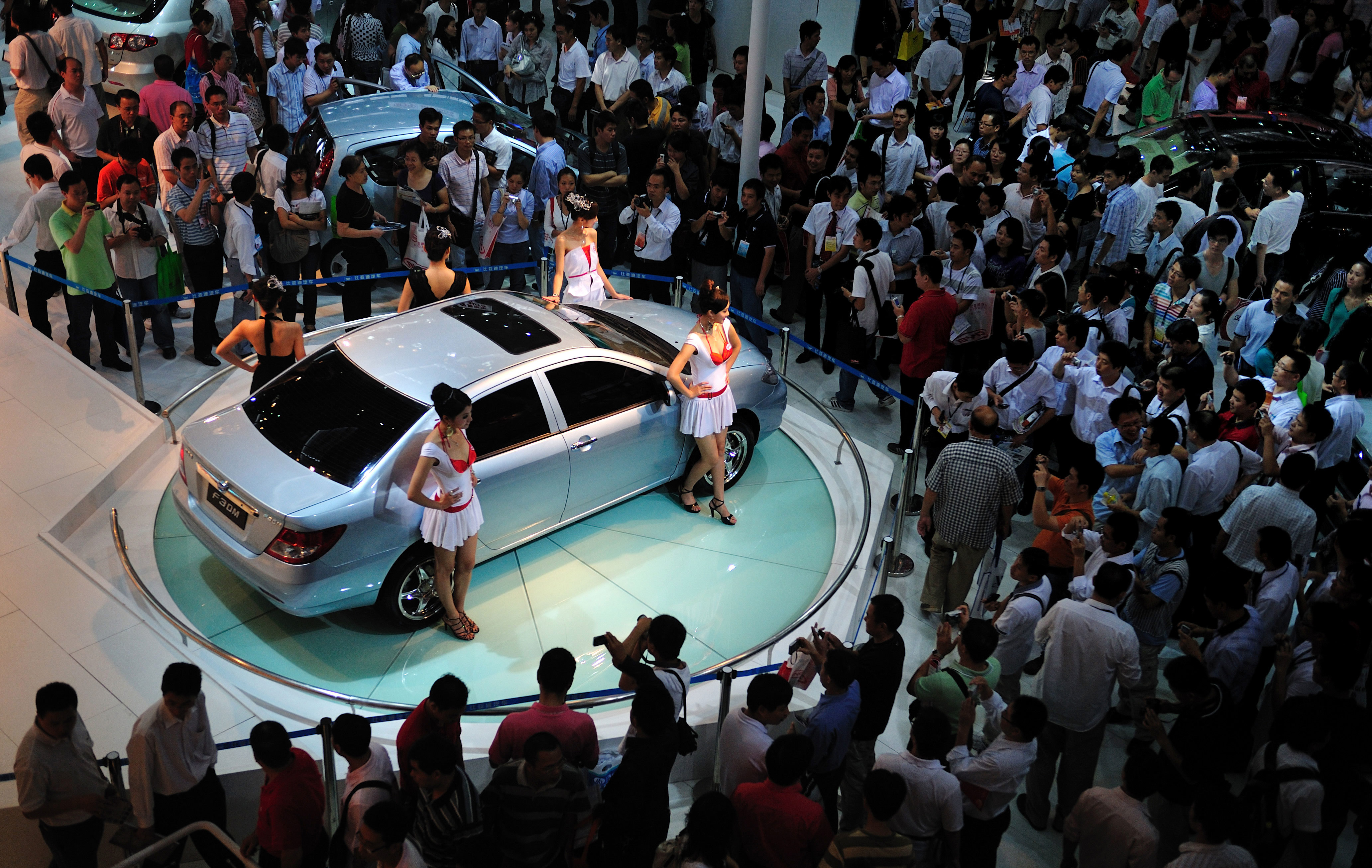 Visitors to a car fair look at a BYD car 