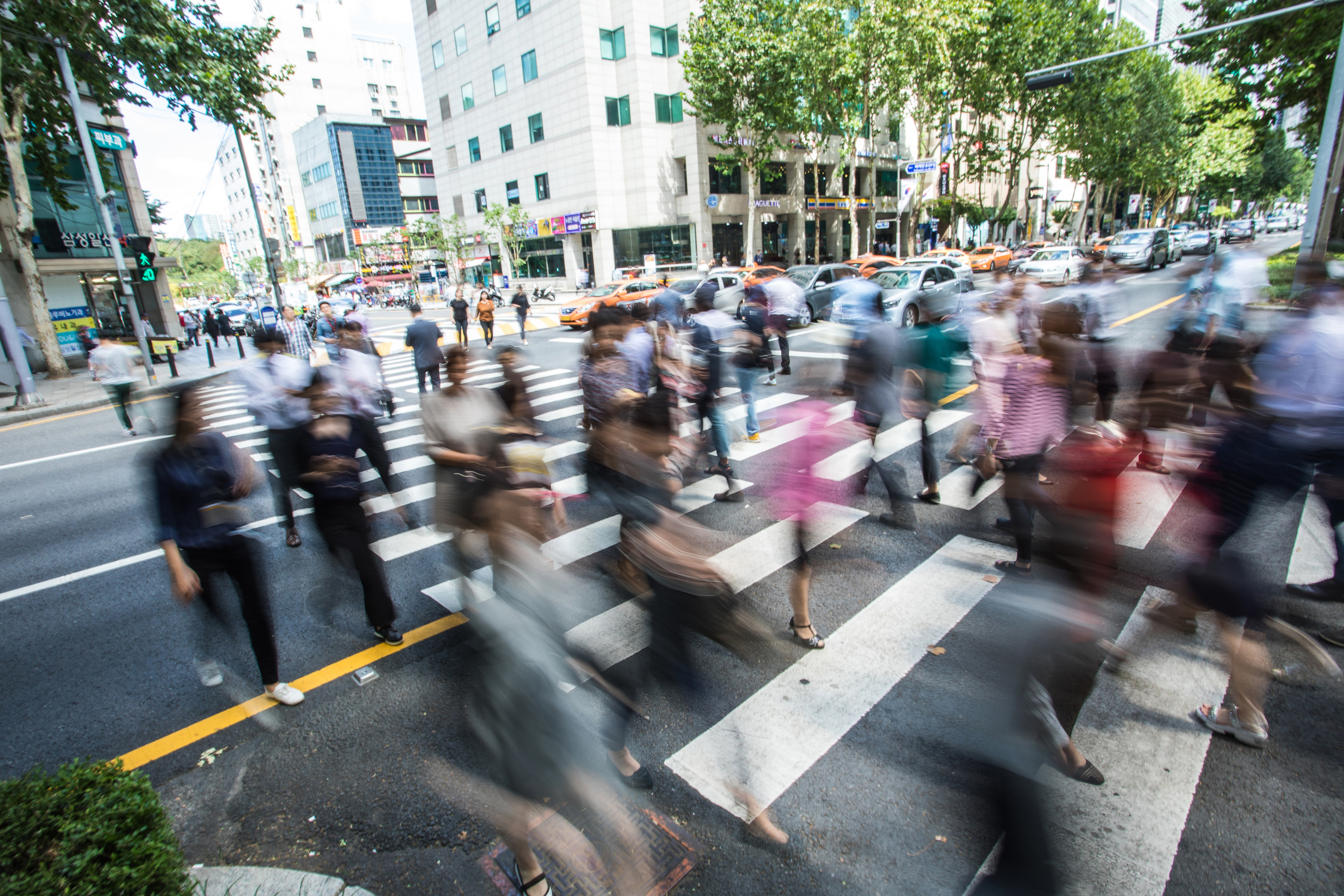 Motion blurred Crowd, unrecognizable pedestrians crossing over the street in Seoul, South Korea