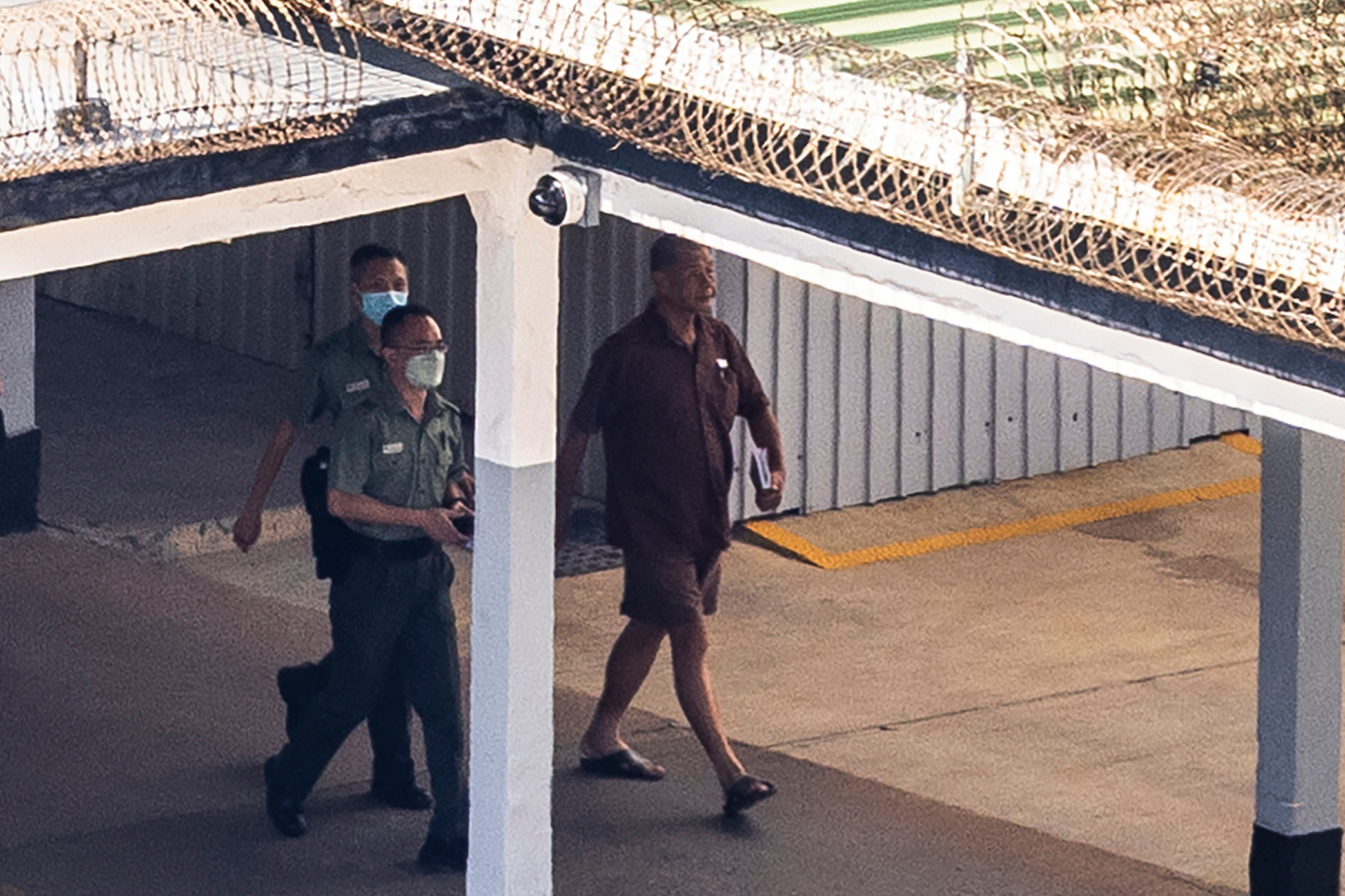 FILE - Hong Kong publisher and prominent pro-democracy activist Jimmy Lai, right, walks through the Stanley prison in Hong Kong, Friday, July 28, 2023. (AP Photo/Louise Delmotte, File)