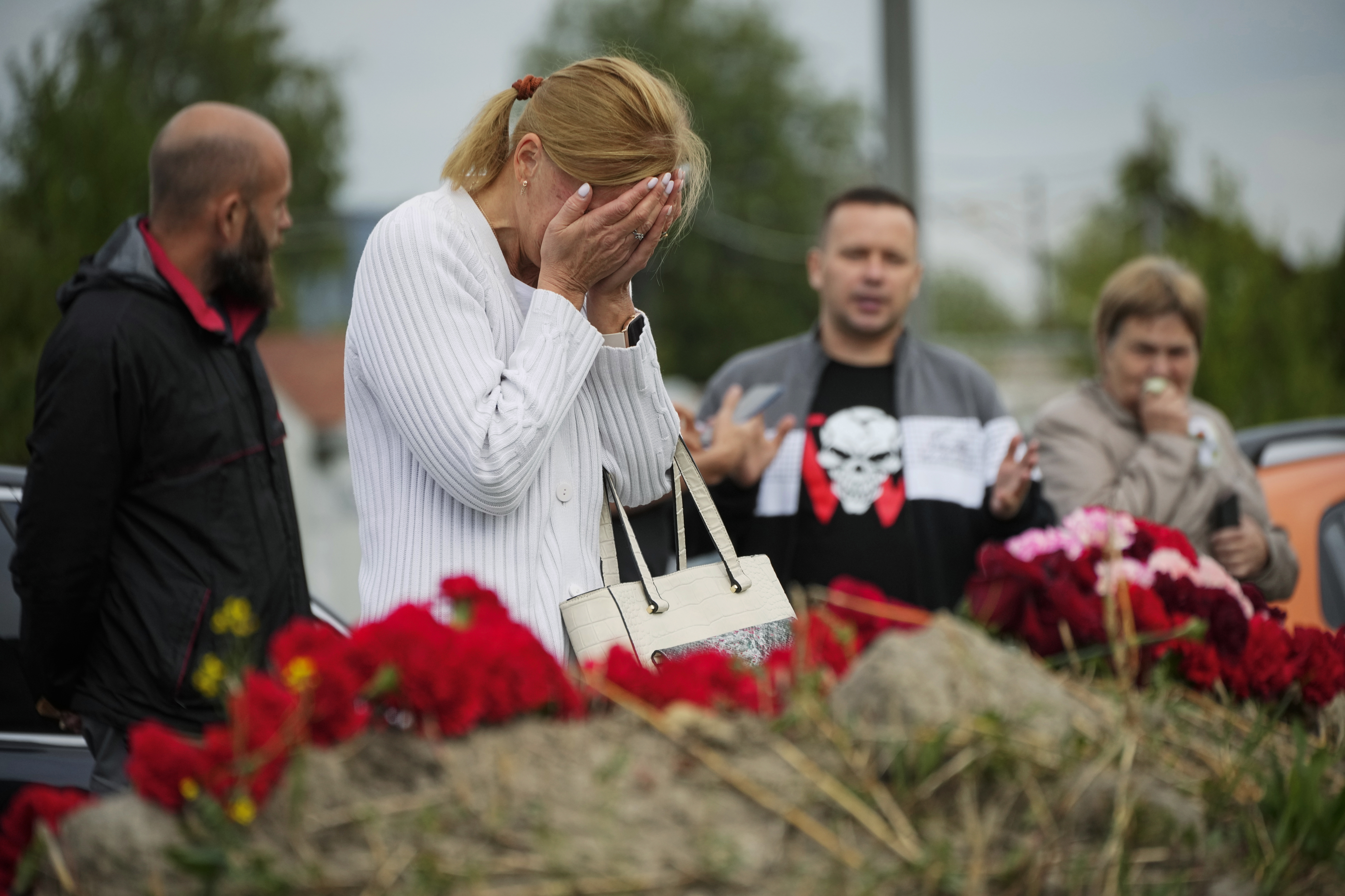 A woman reacts at an informal memorial next to the former 'PMC Wagner Centre' in St. Petersburg, Russia, Thursday, Aug. 24, 2023.
