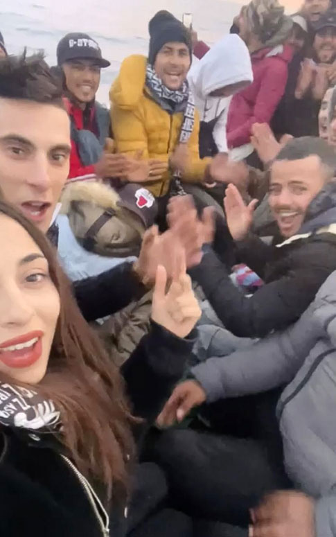 Chaima Ben Mahmoude, Ben Mahmoude (left) and her fiancé pose with others on a boat as they cross the Mediterranean on their way to Europe.