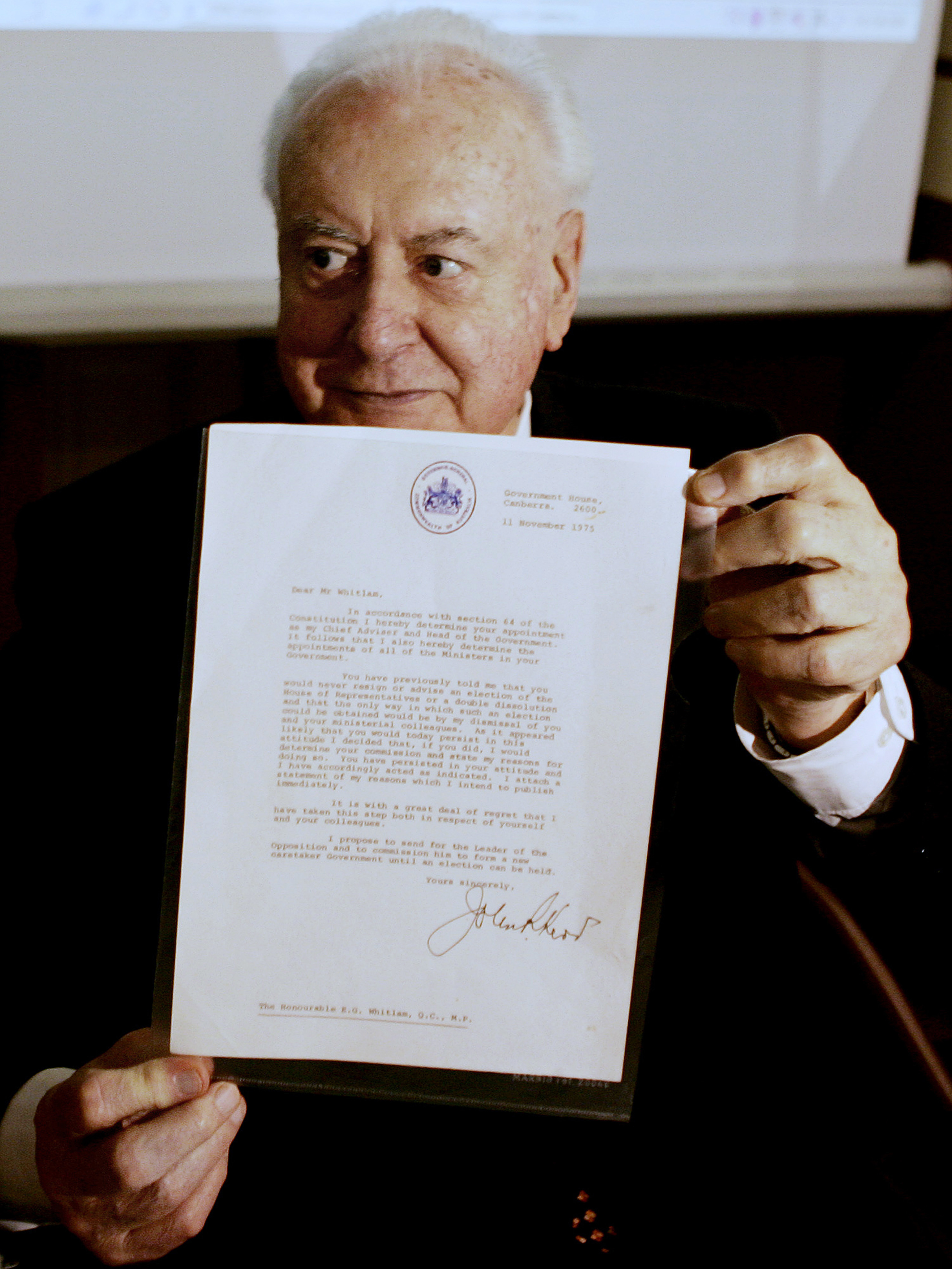 In this November 7, 2005 file photo, former Australian Prime Minister Gough Whitlam holds up the original copy of his dismissal letter he received from then Governor General Sir John Kerr on the 11th of November 1975 at a book launch in Sydney, Australia. Historian, Professor Jenny Hocking, is going to court this month in an attempt to force Australian authorities to release secret letters that would reveal what Queen Elizabeth II knew of her representative's sho