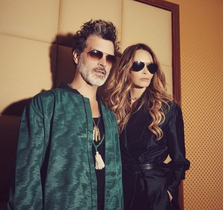Elle Macpherson with boyfriend Doyle Bramhall, she wears black outfit while he wears a black outfit and deep green jacket