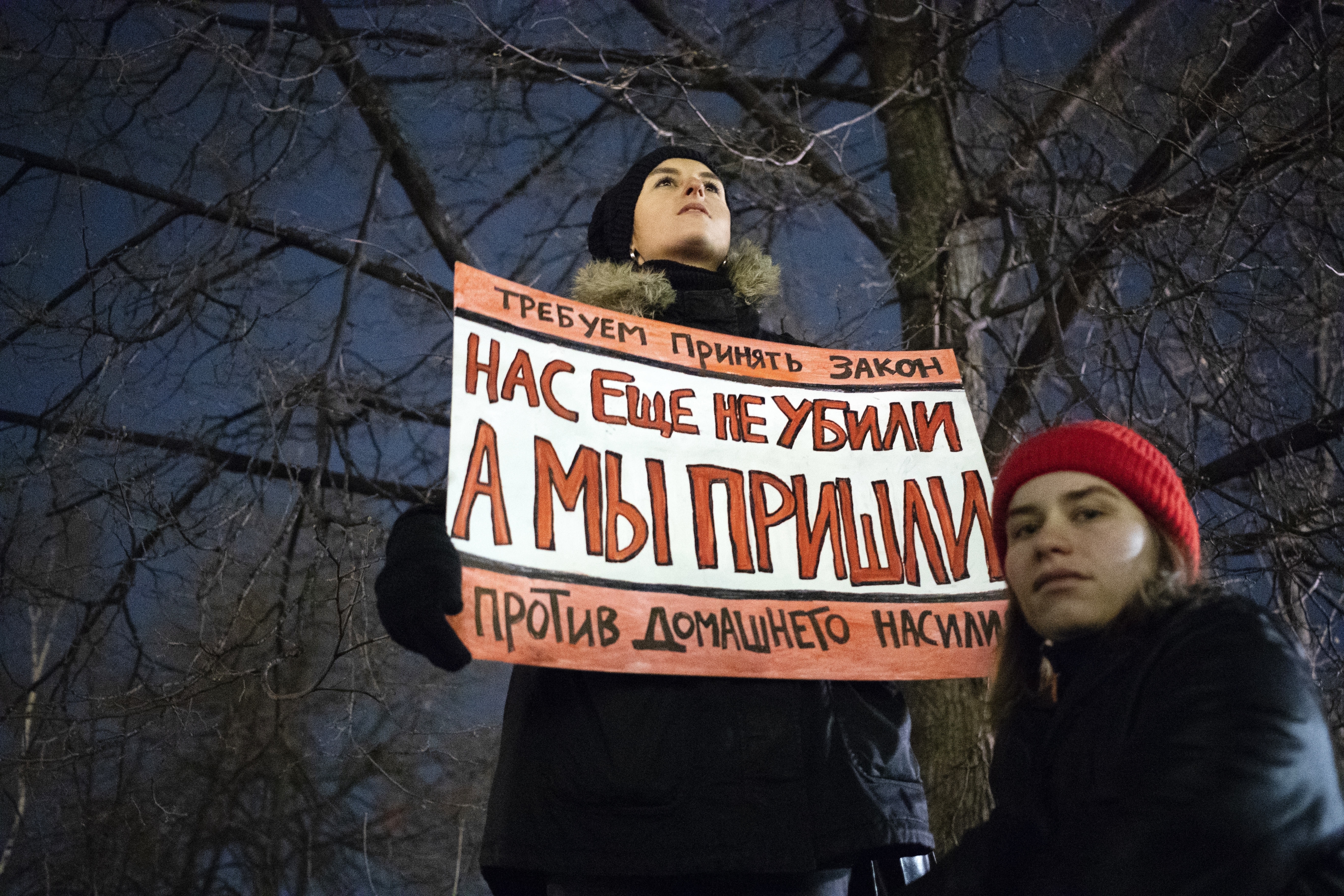 A woman holds a banner demanding Russia to change domestic violence laws. 