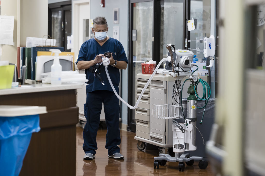 A healthcare worker holds an oxygen respirator tube in the Covid-19 Intensive Care Unit (ICU) at Freeman Hospital West in Joplin, Missouri, U.S., on Tuesday, Aug. 3, 2021. Hospitals in states where Covid-19 cases are once again surging are beginning to feel the strain in their emergency departments and intensive care units. Photographer: Angus Mordant/Bloomberg